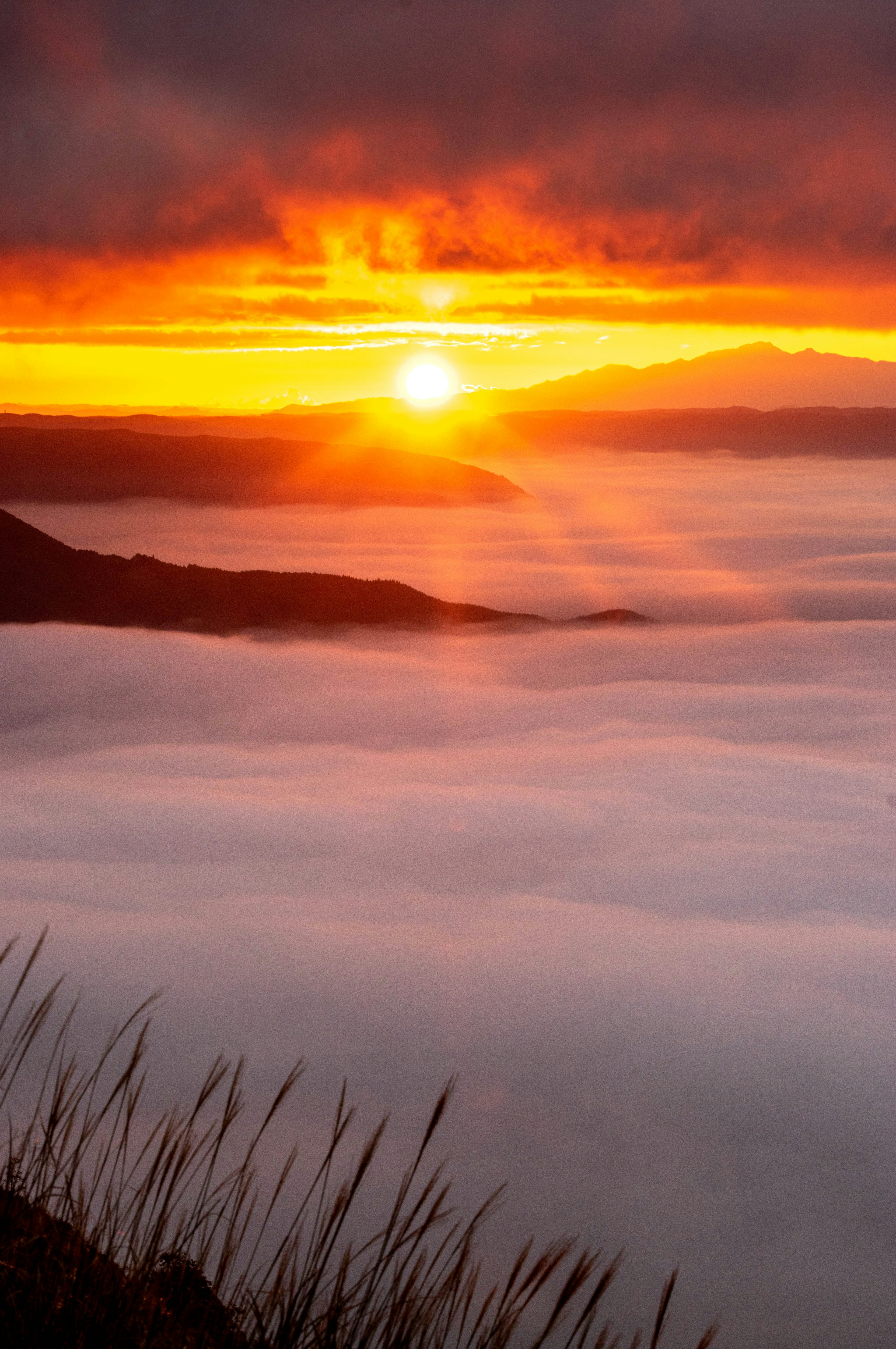 Sunrise over a sea of clouds with mountain silhouette