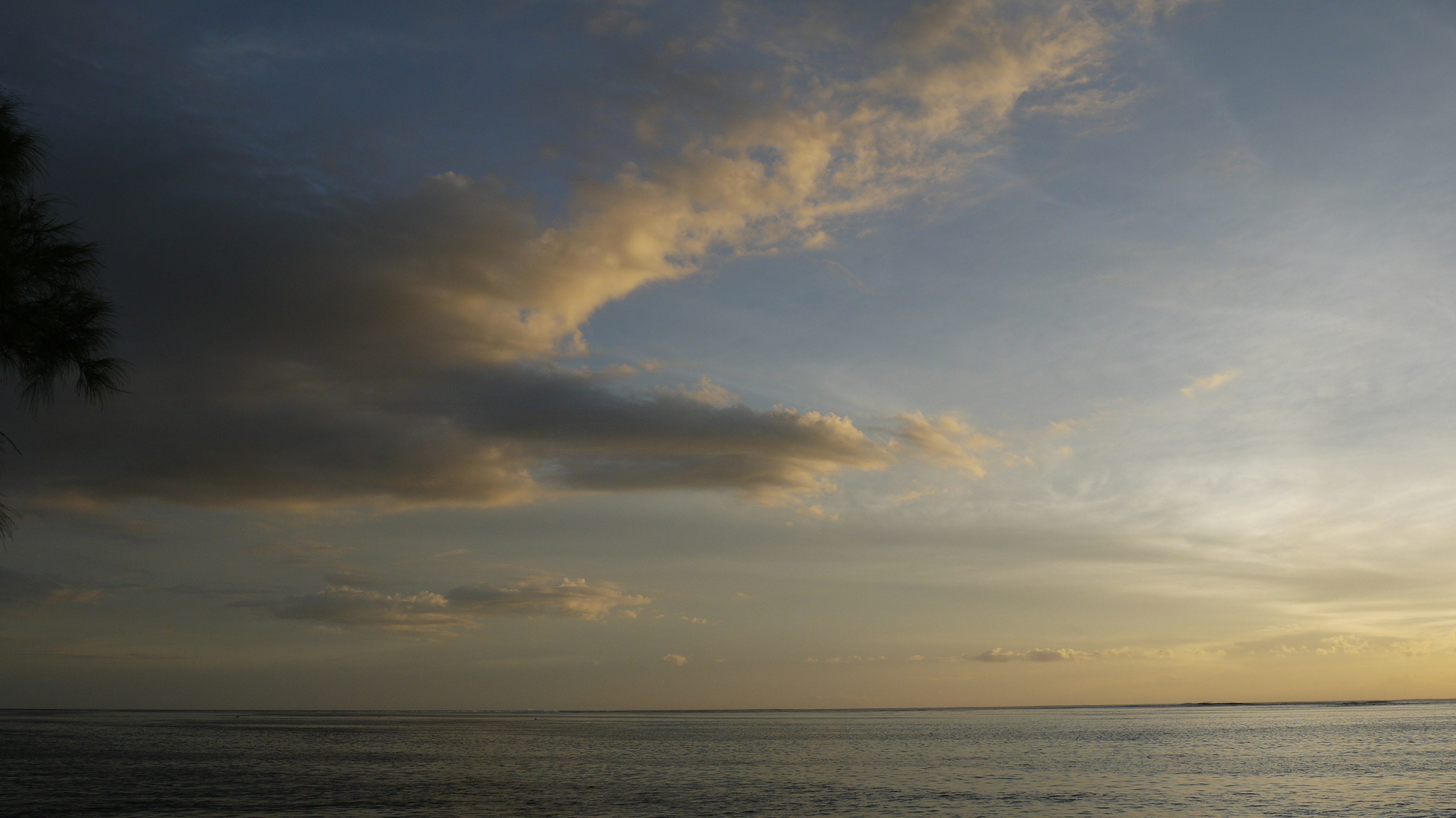 海洋的美景，蓝天和云朵柔和的日落光线反射在水面上