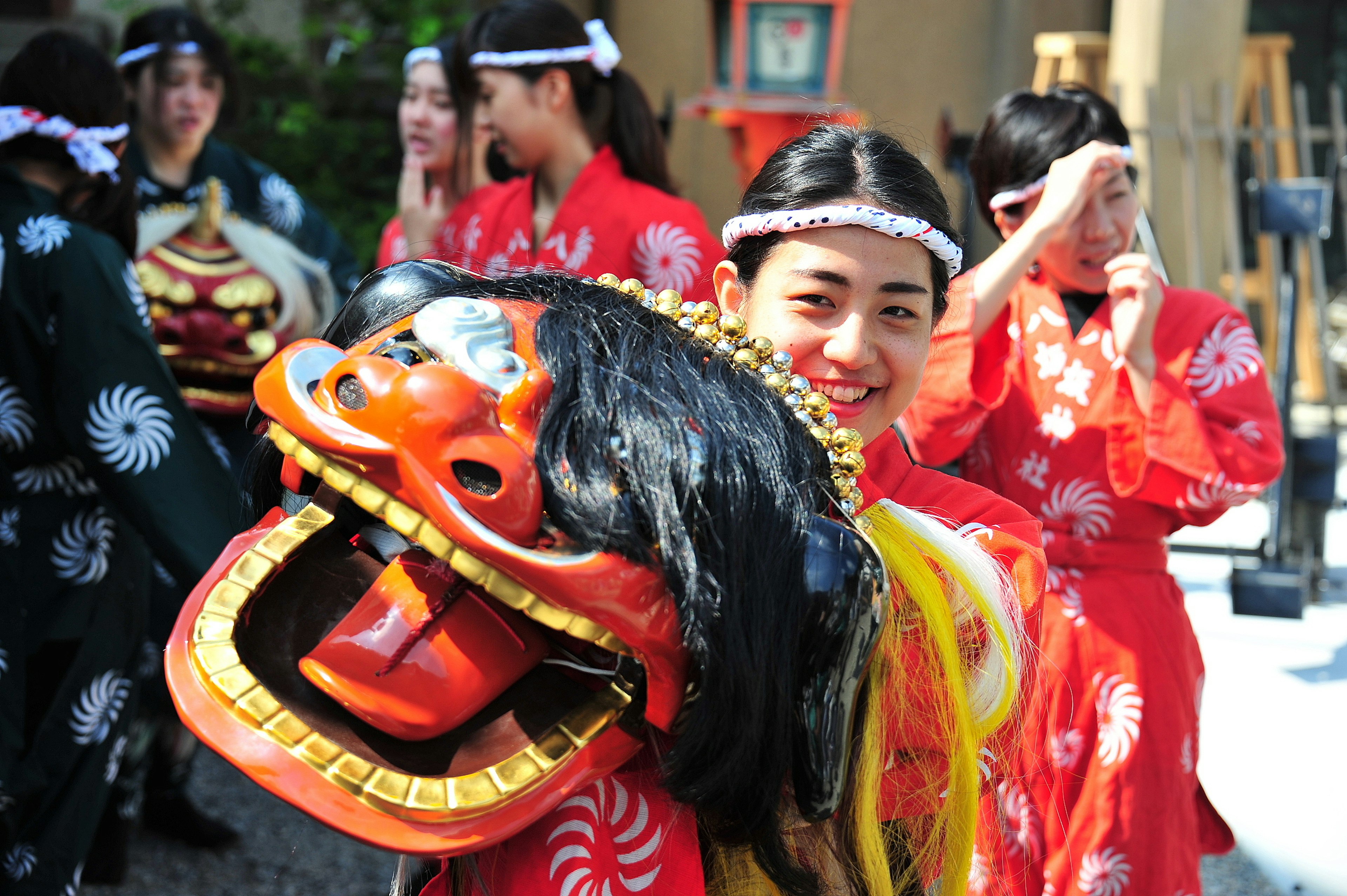 Adegan wanita dalam pakaian festival memegang topeng singa selama parade