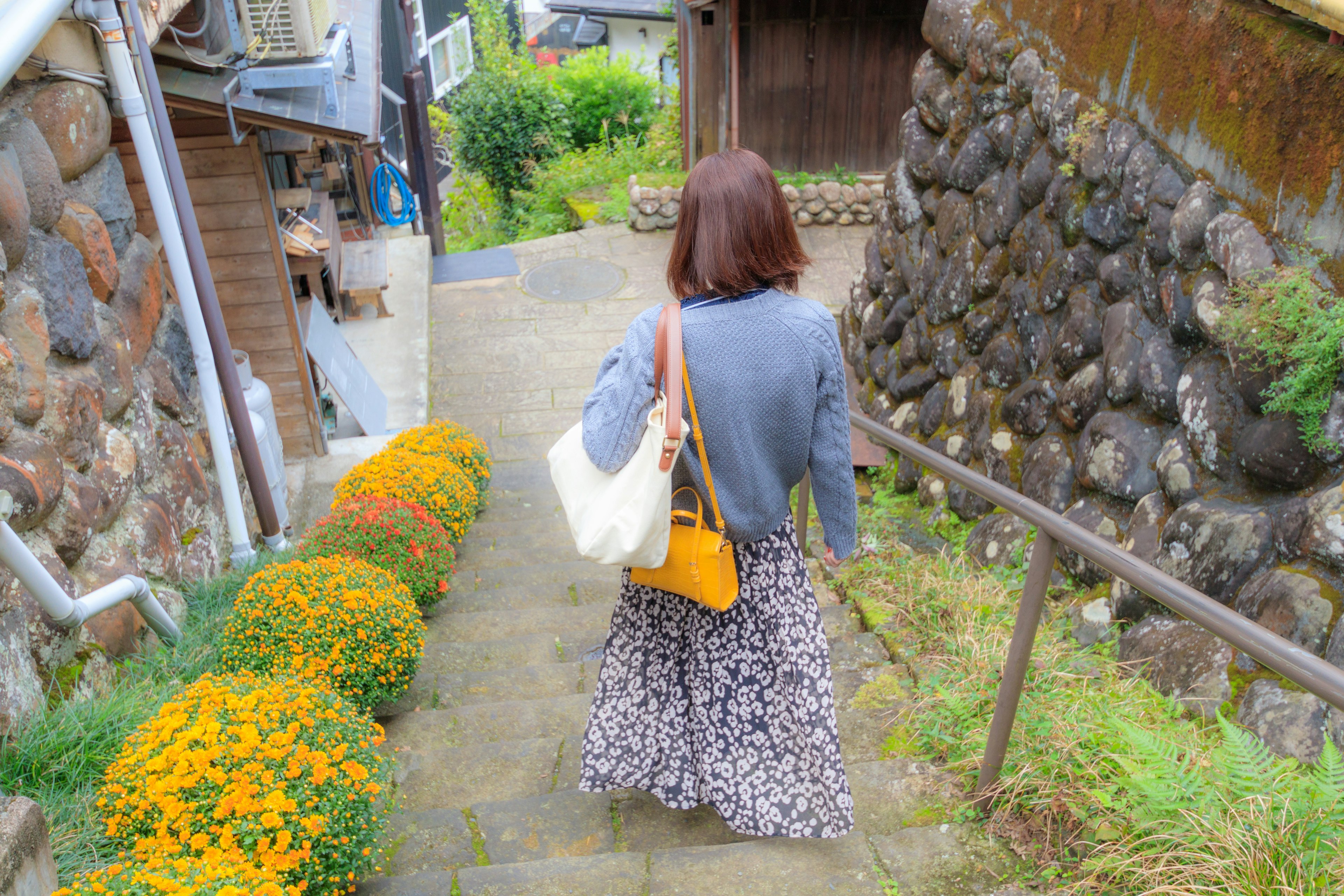 Une femme marchant sur un chemin bordé de fleurs