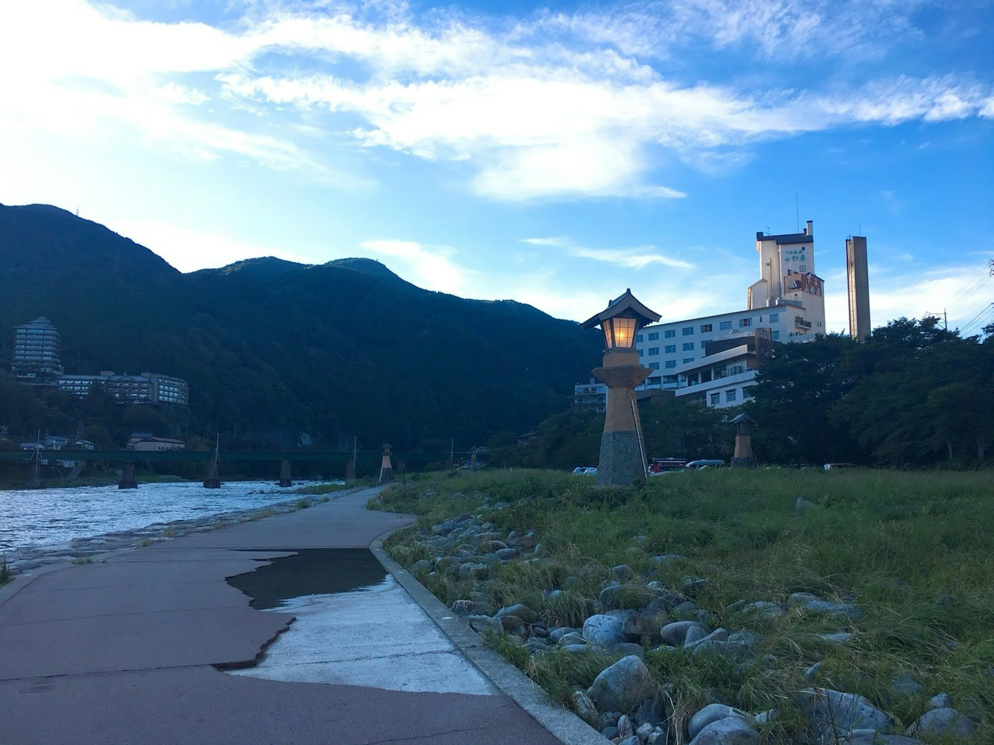 Scenic riverside view with mountains and a hotel in the background