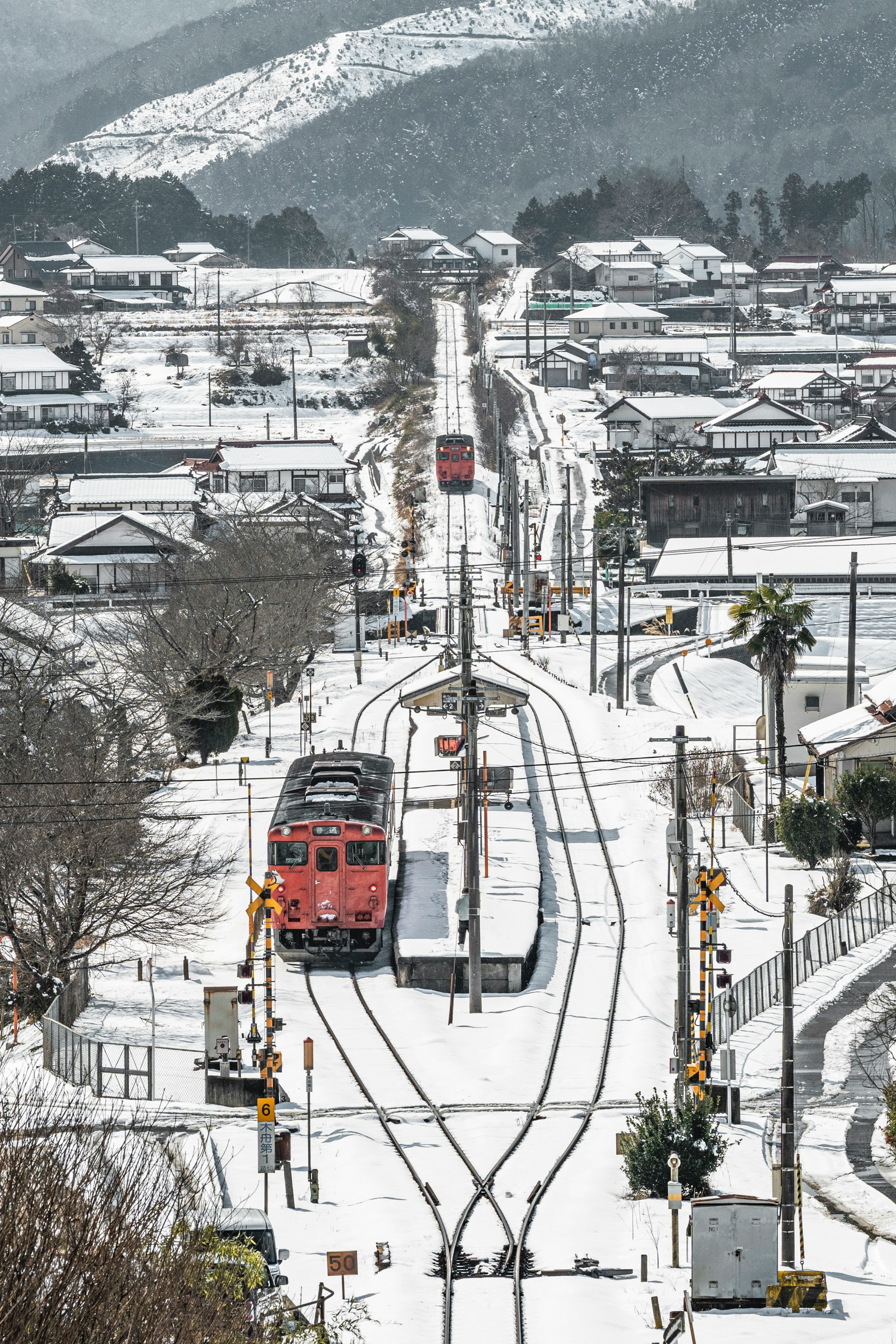 Treni rossi e bianchi che viaggiano attraverso un paesaggio innevato