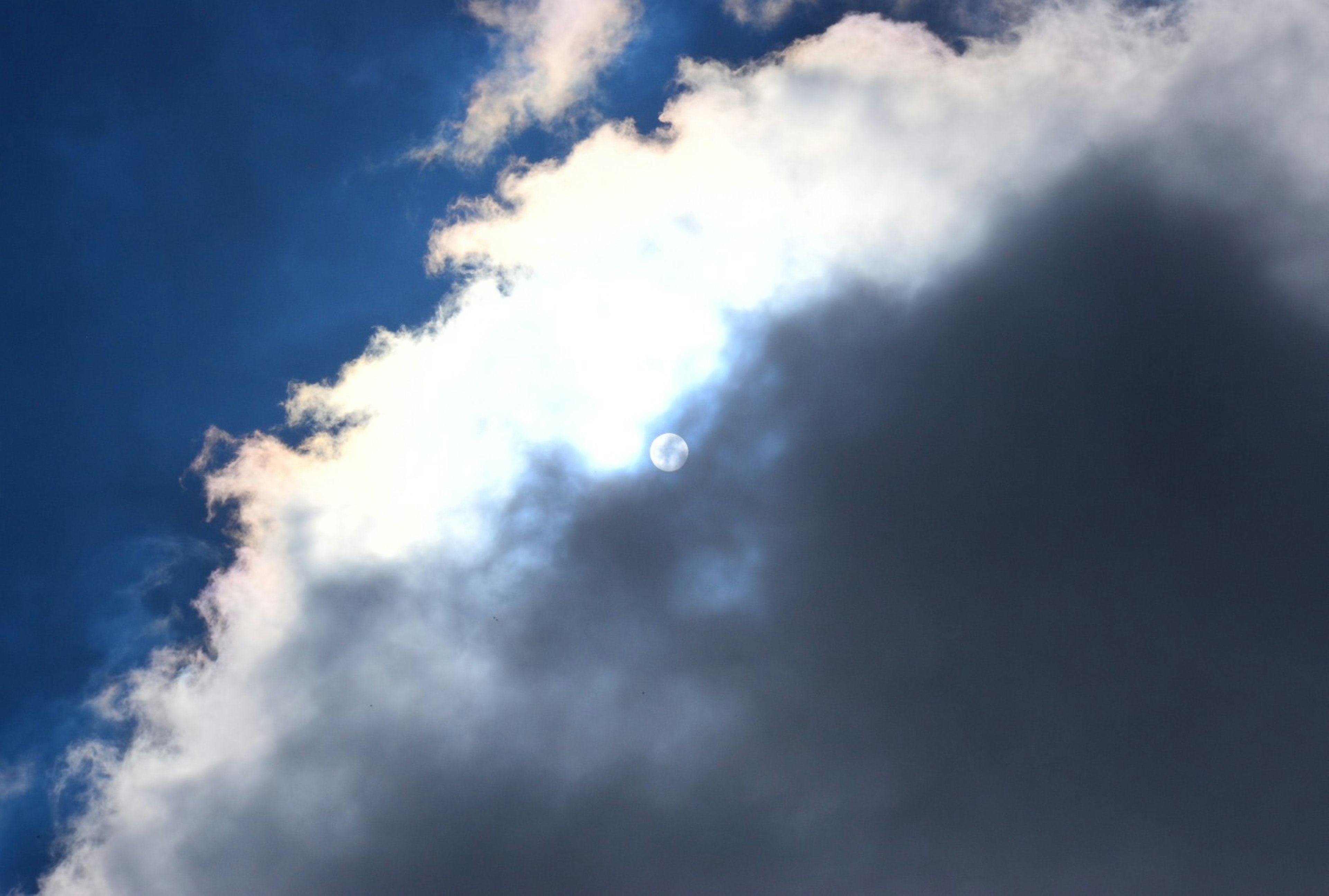 Sonnenlicht sichtbar durch Wolken vor einem blauen Himmel