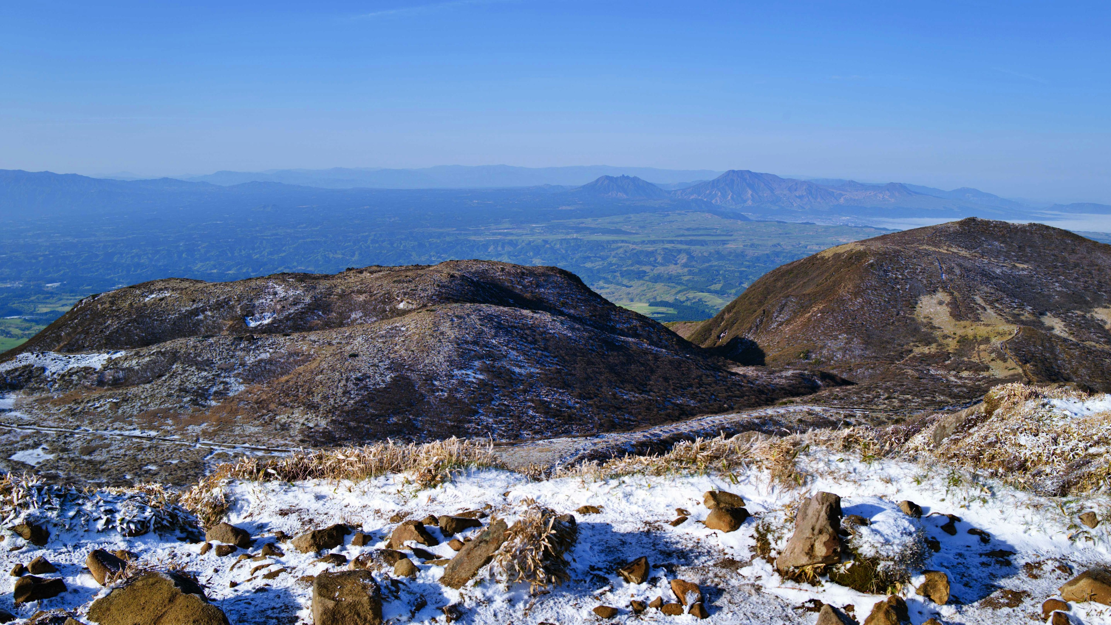 Panoramablick auf verschneite Berge mit entfernten Hügeln