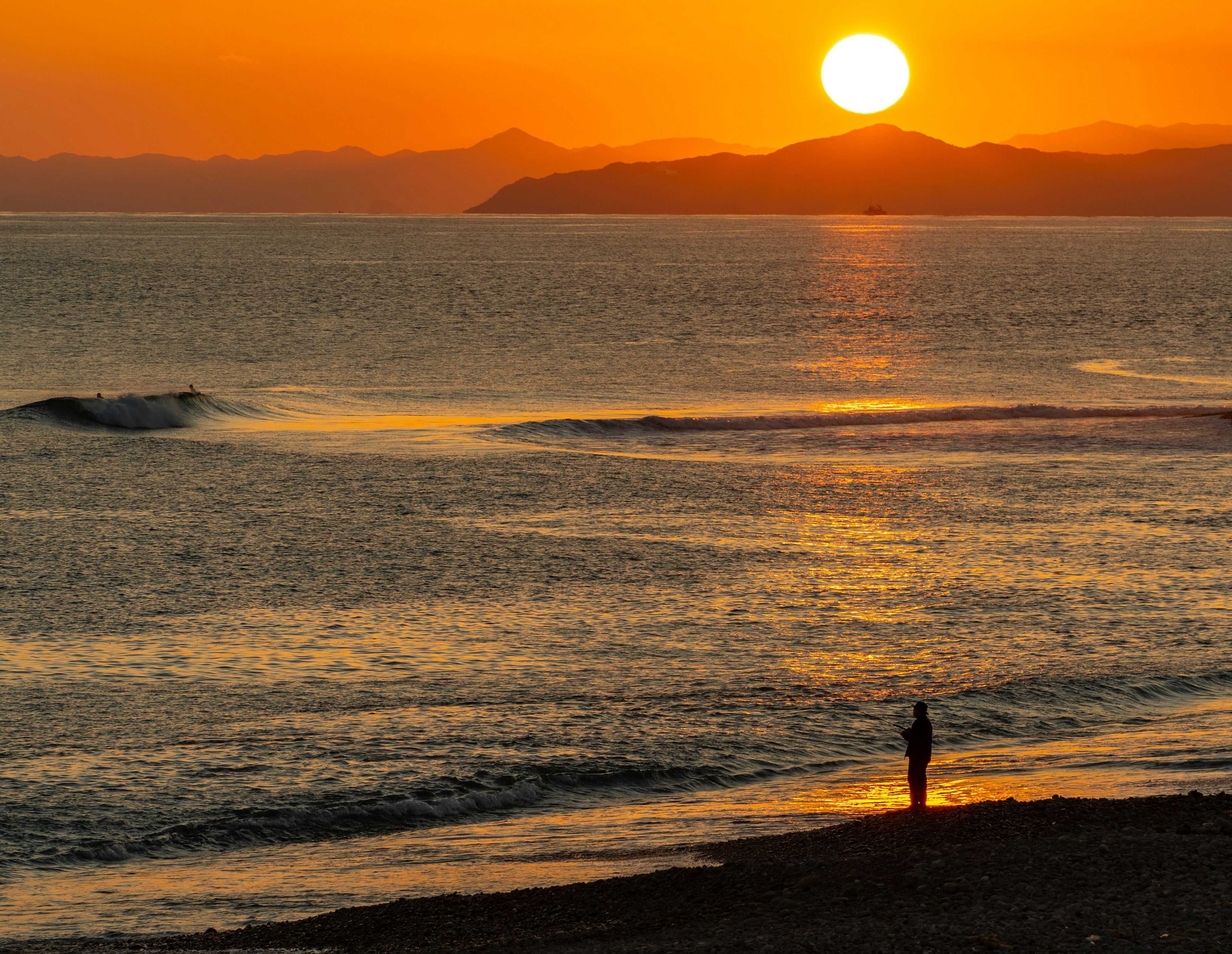 Coucher de soleil magnifique sur l'océan avec une personne debout sur la plage