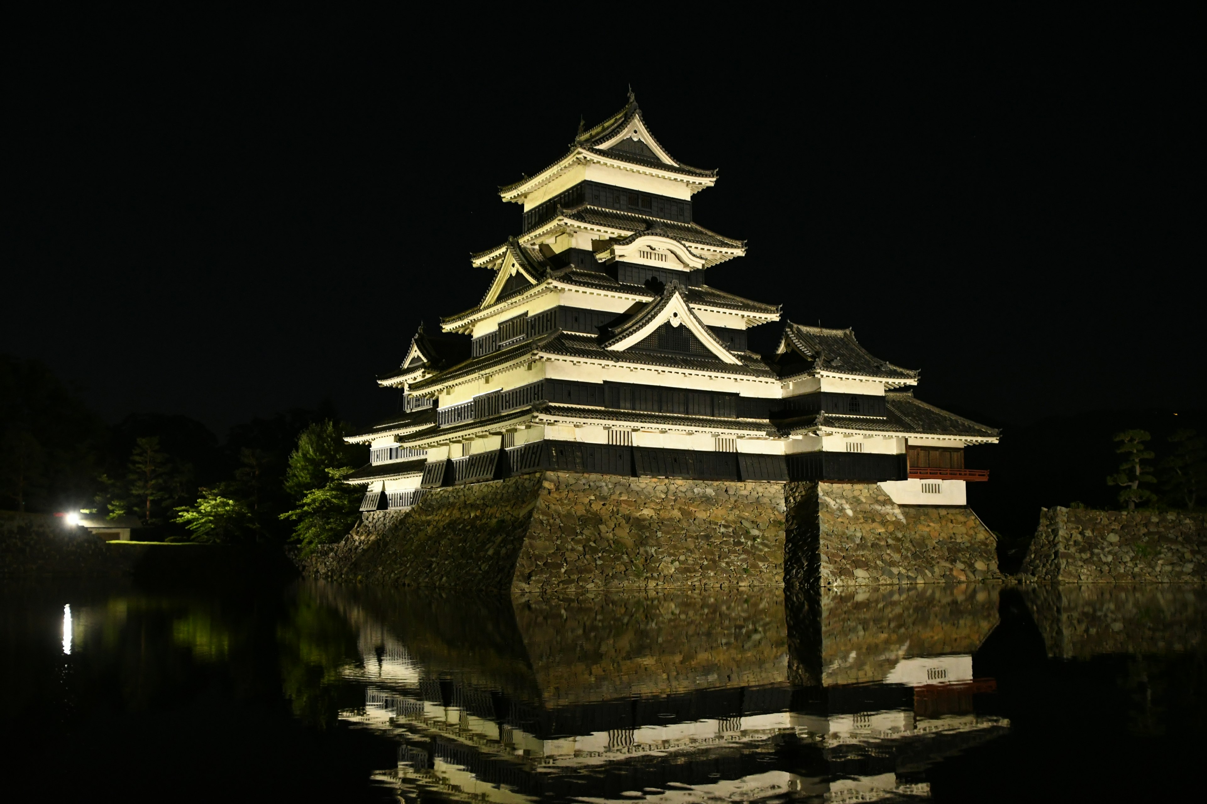 Matsumoto Schloss bei Nacht mit schönen Reflexionen und Beleuchtung