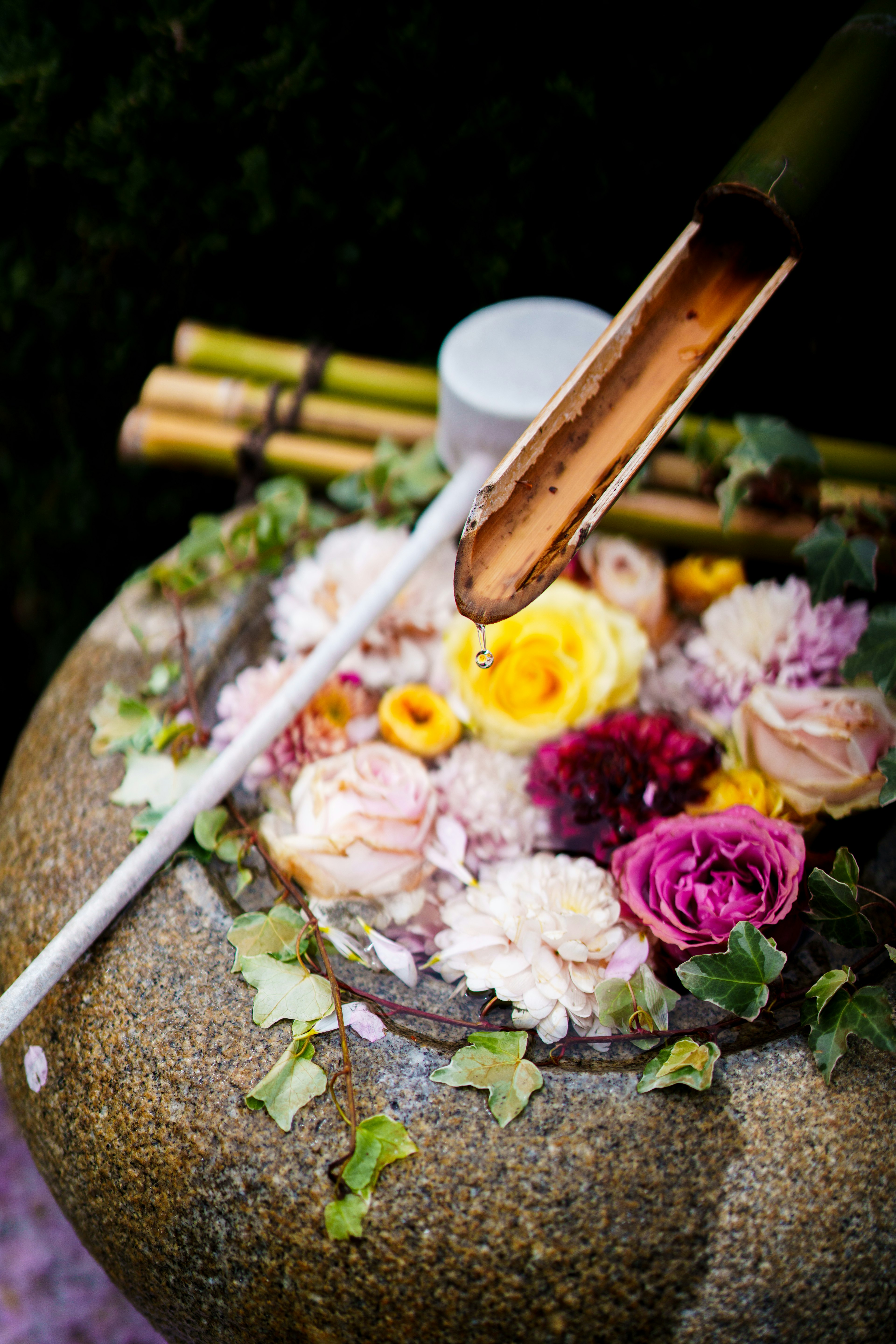 Stone water basin decorated with bamboo and colorful flowers