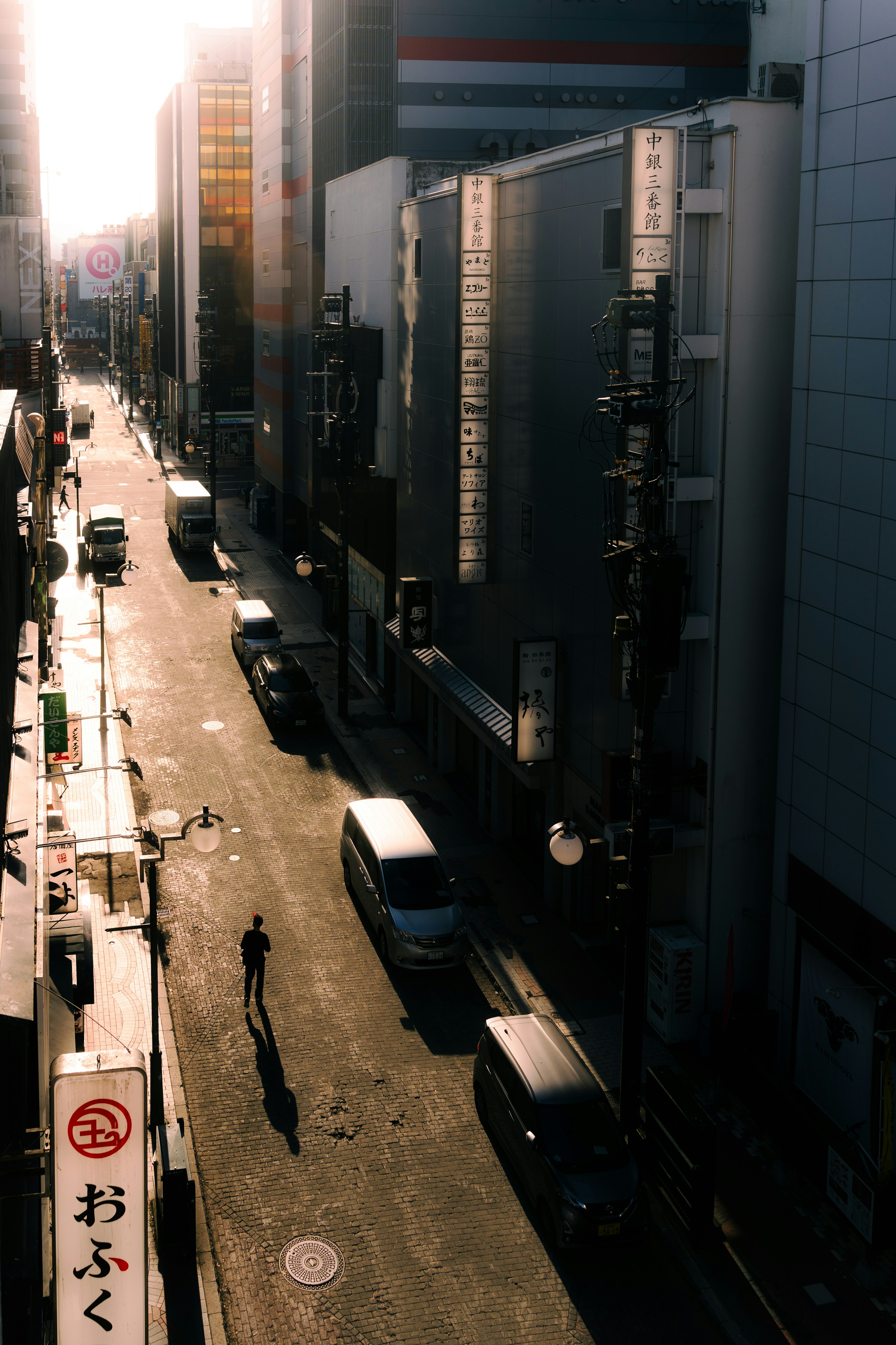 Escena de calle con la silueta de una persona bajo el atardecer