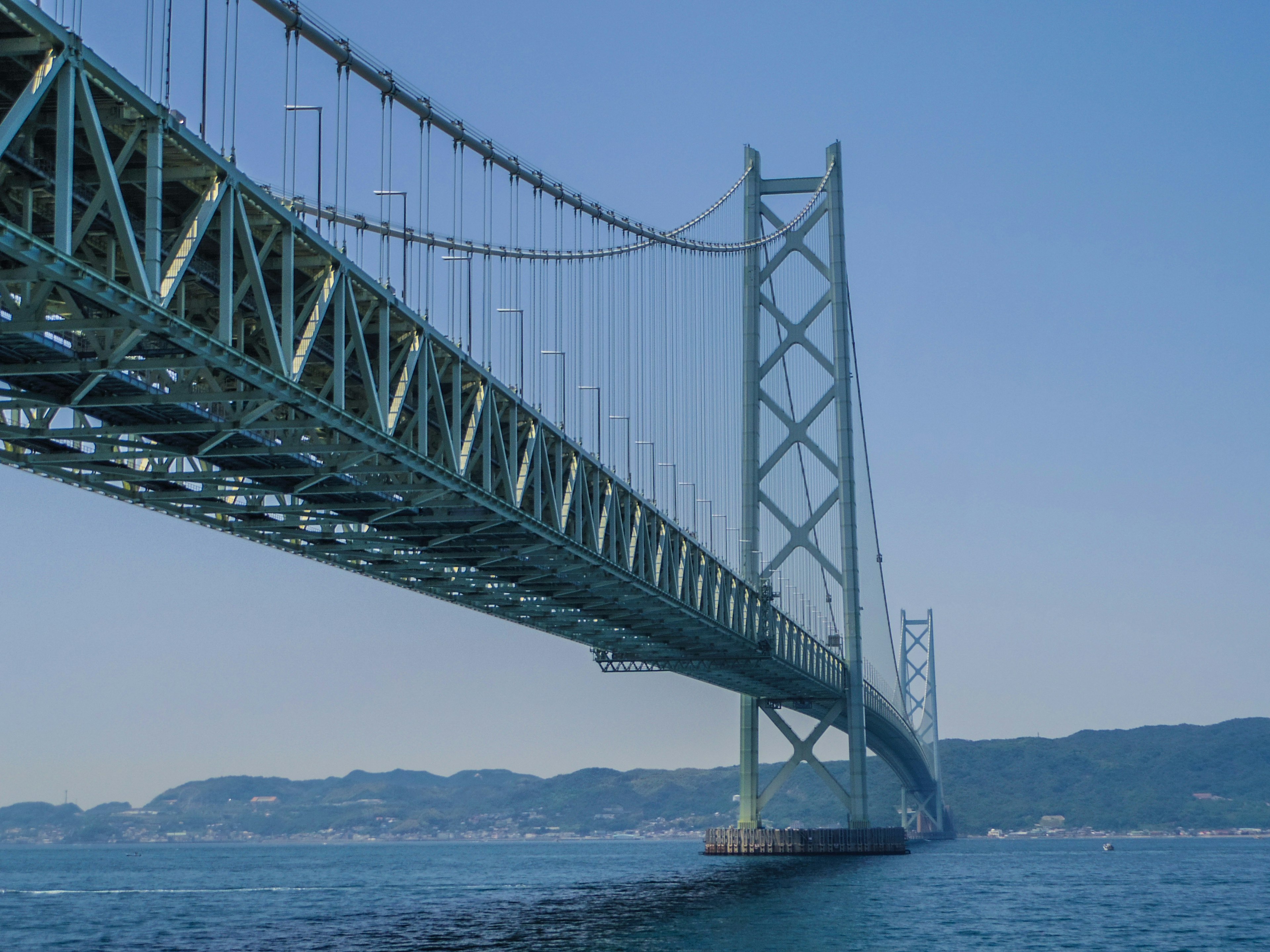 Pont Akashi Kaikyō avec une structure diagonale sous un ciel bleu clair