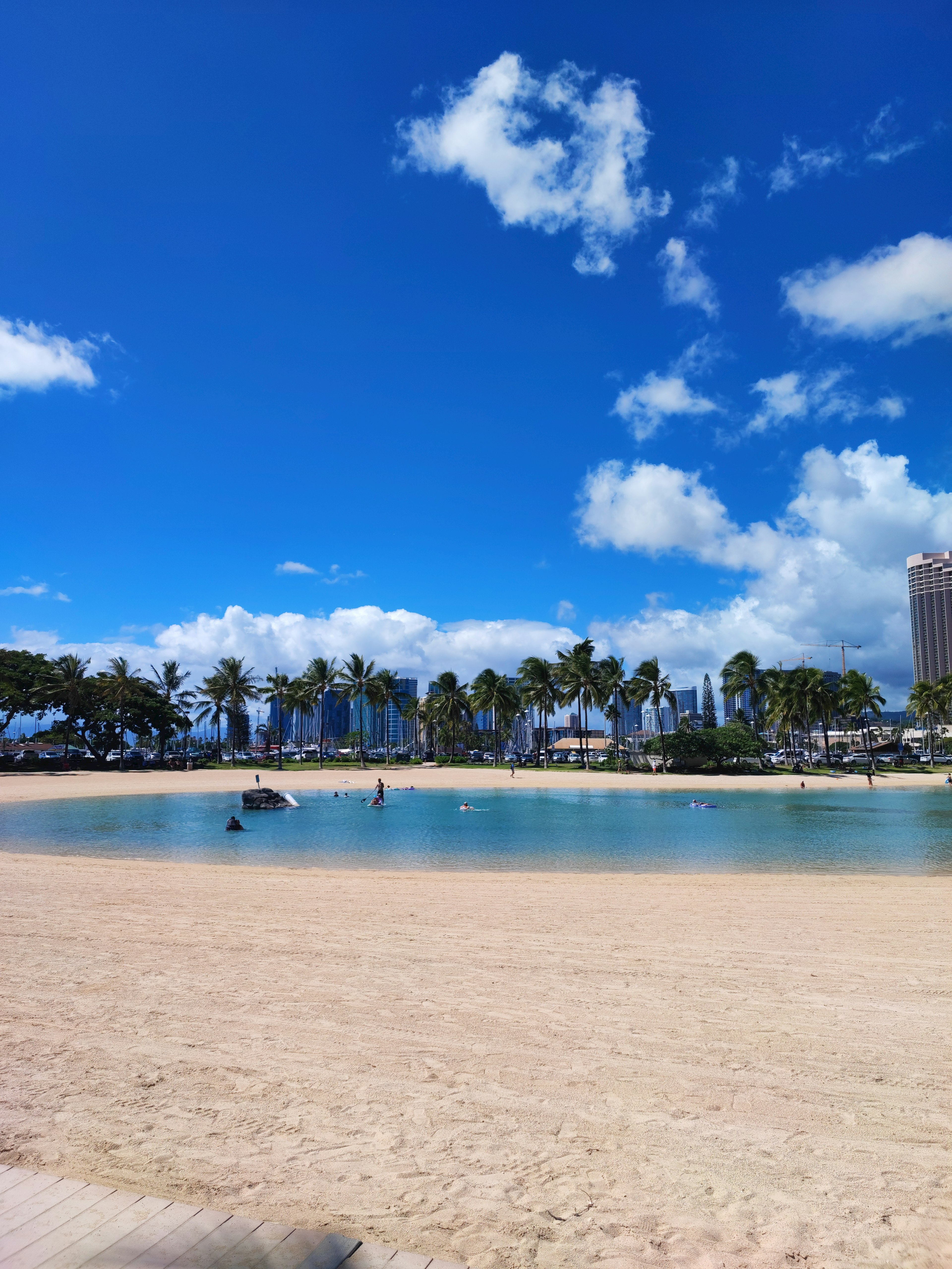 Scène de plage avec ciel bleu et nuages blancs Personnes sur la plage avec des gratte-ciels en arrière-plan