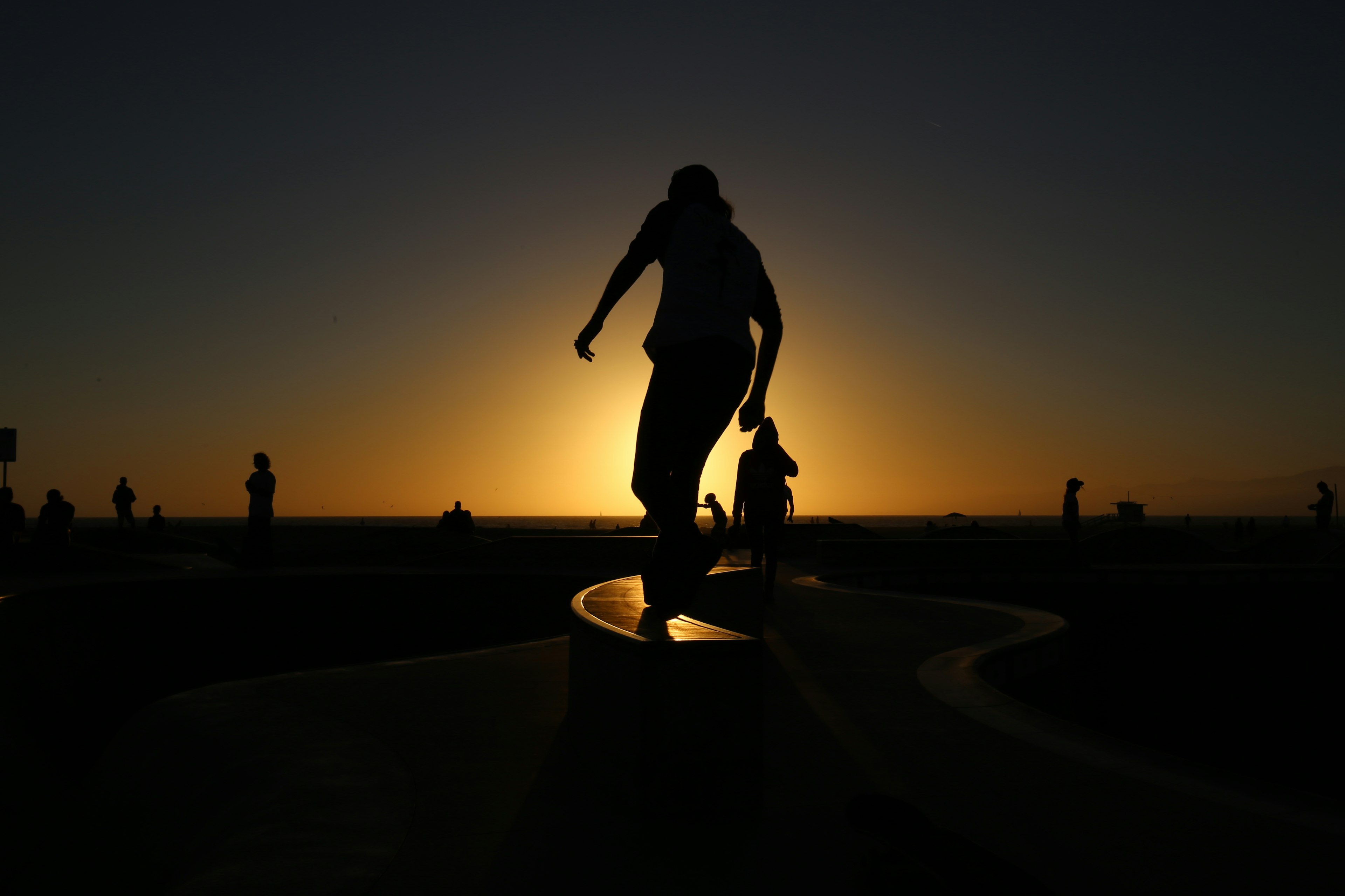 Silhouette of a person skateboarding against a sunset