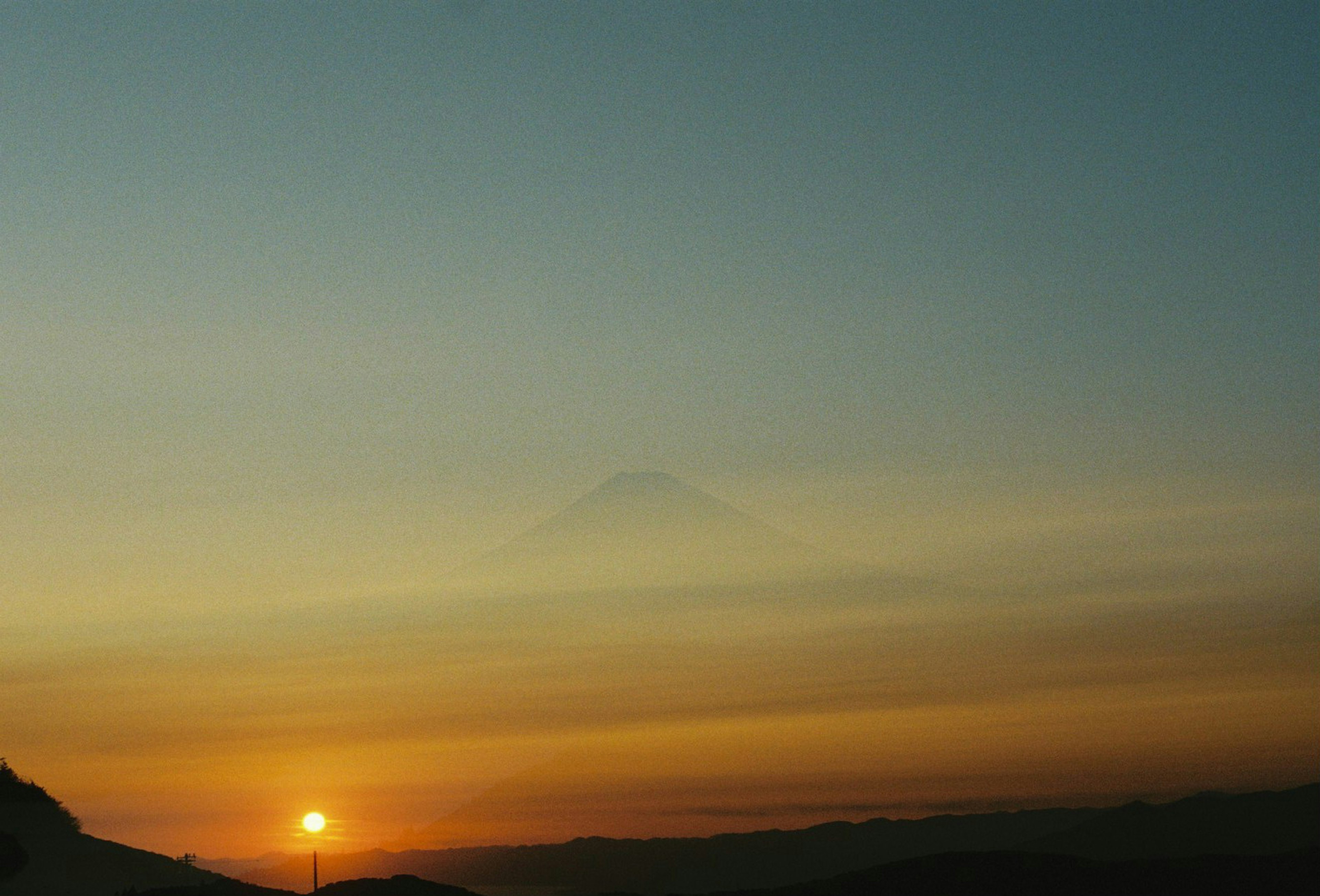 Beautiful landscape with sunset mountains and sky in bright orange and blue hues