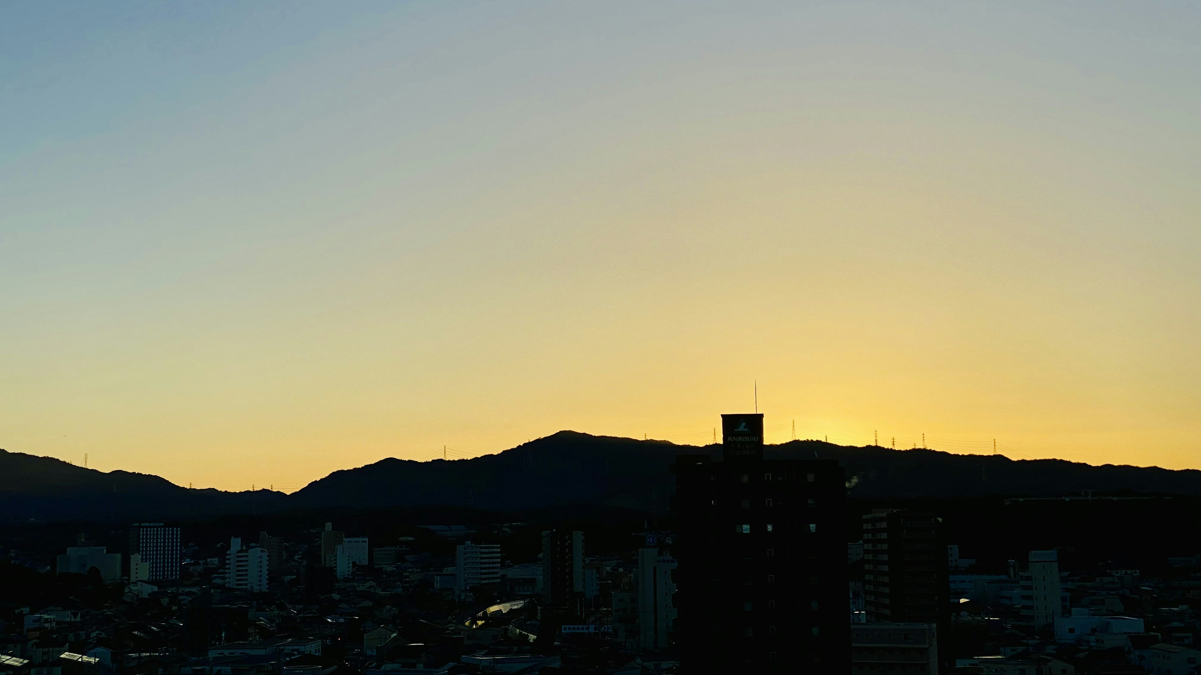 Vista del atardecer sobre montañas y el horizonte de la ciudad