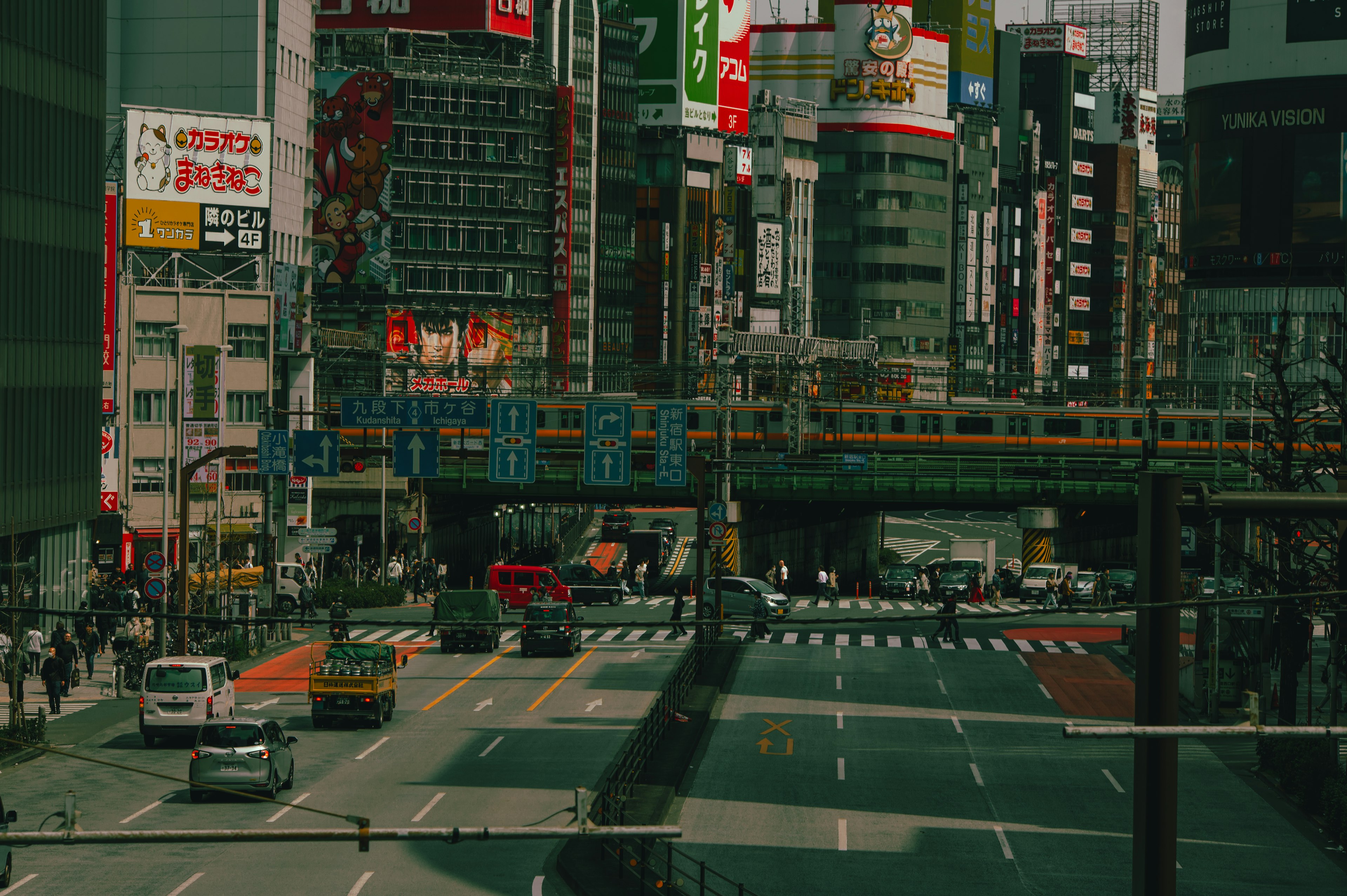 Busy cityscape with people walking a train bridge and bustling streets