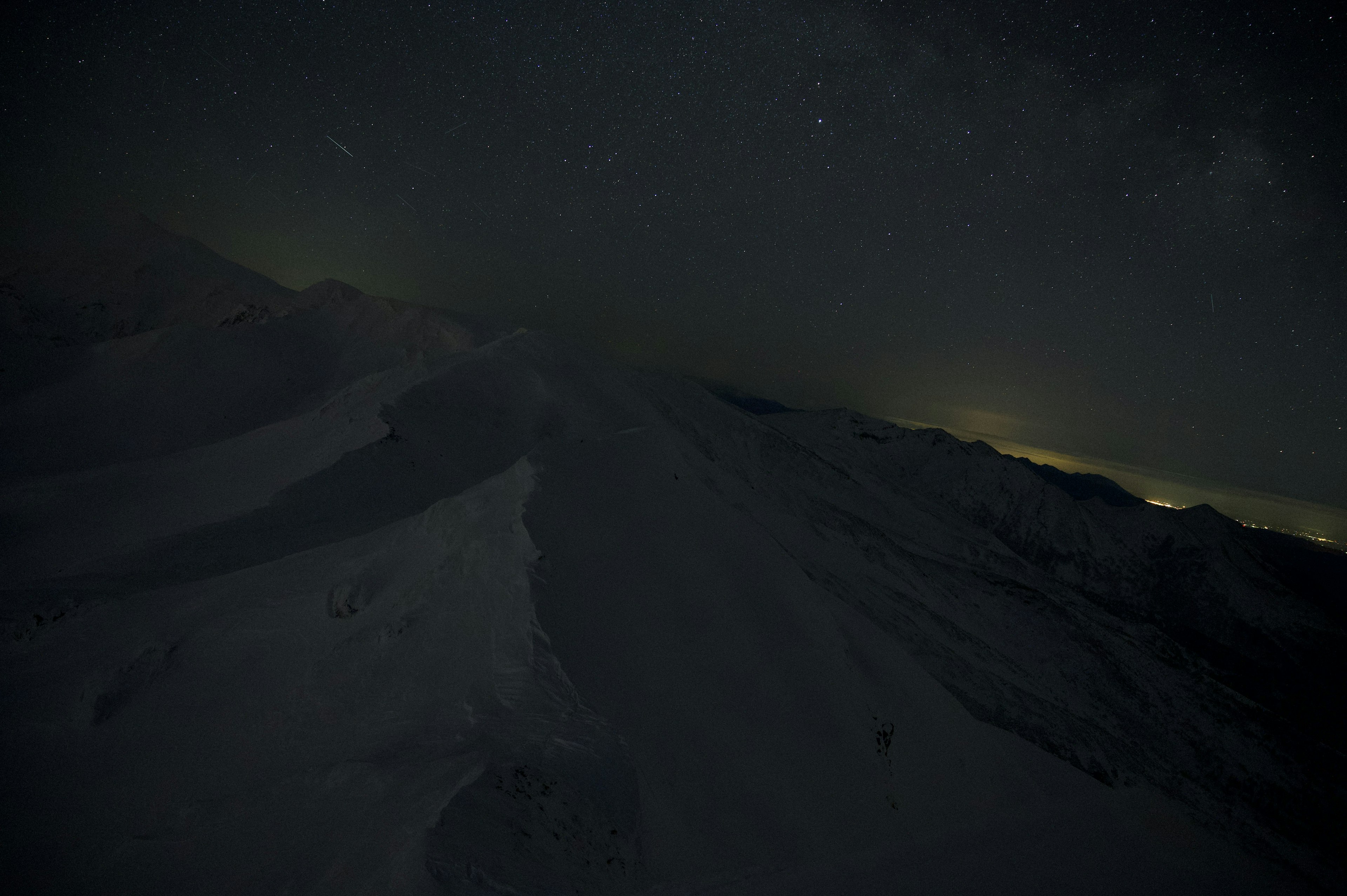 夜空に星が輝く雪山の風景