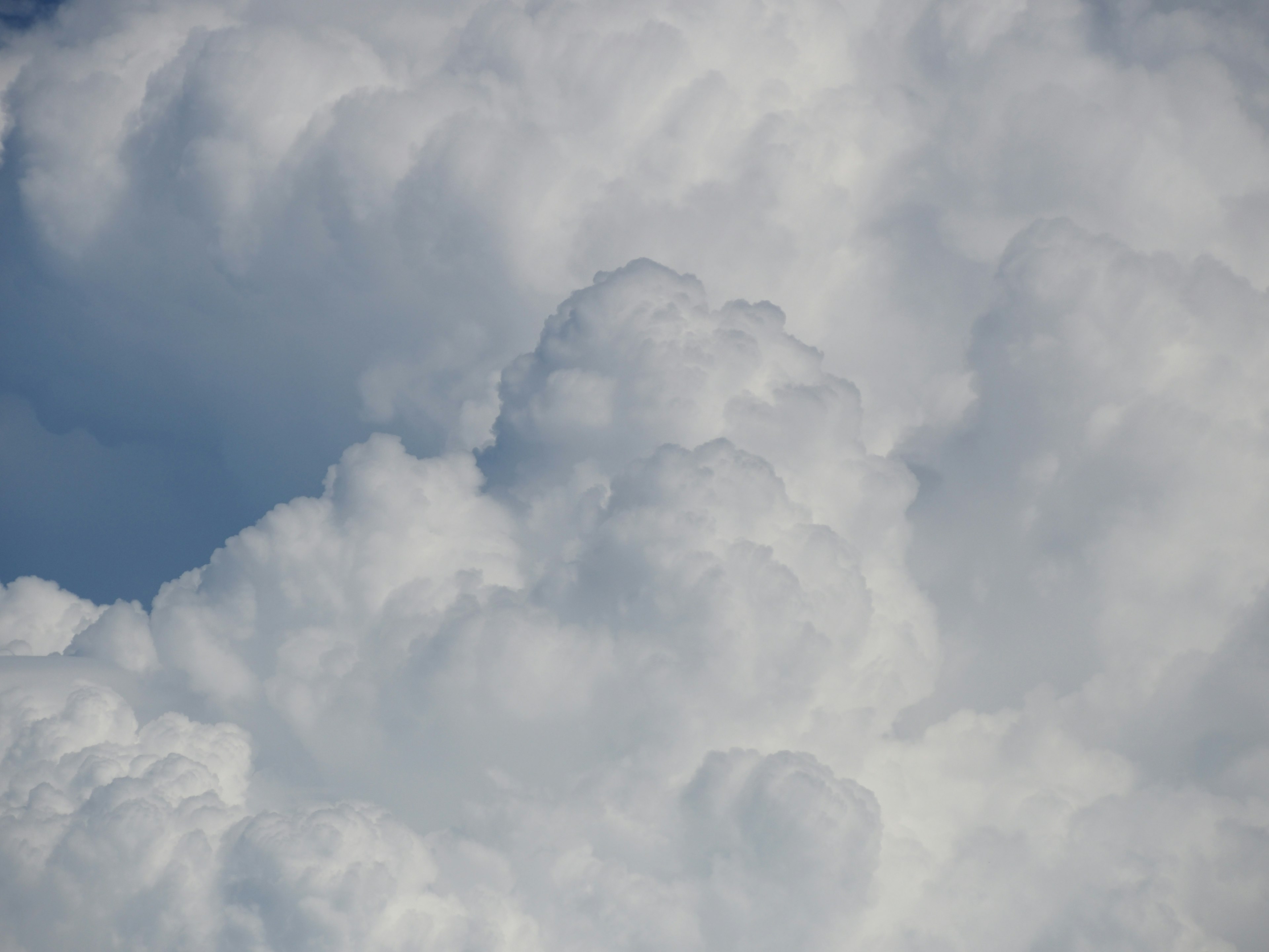 Close-up awan putih berbulu lembut di langit biru