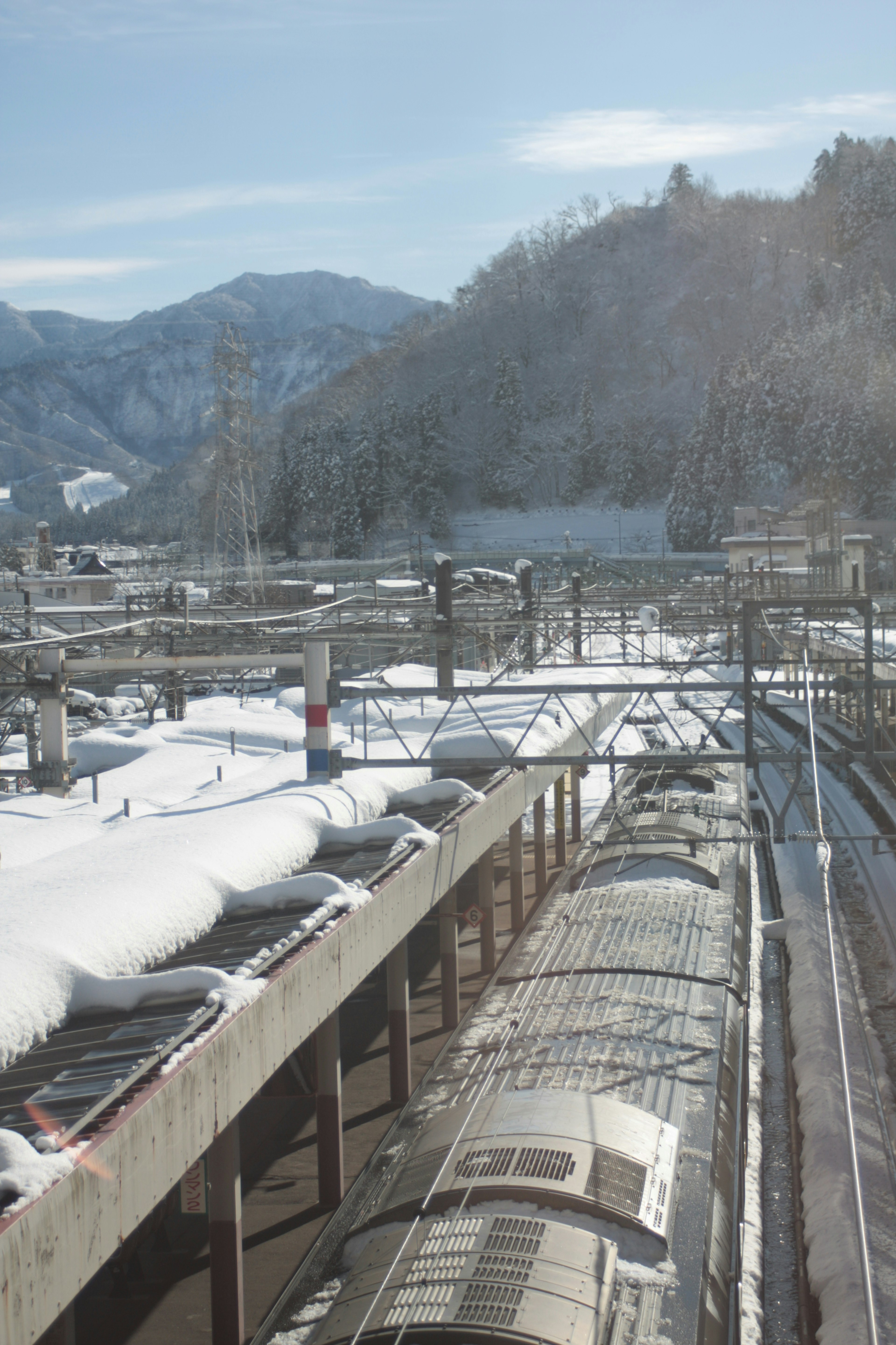 Escena ferroviaria cubierta de nieve con montañas de fondo