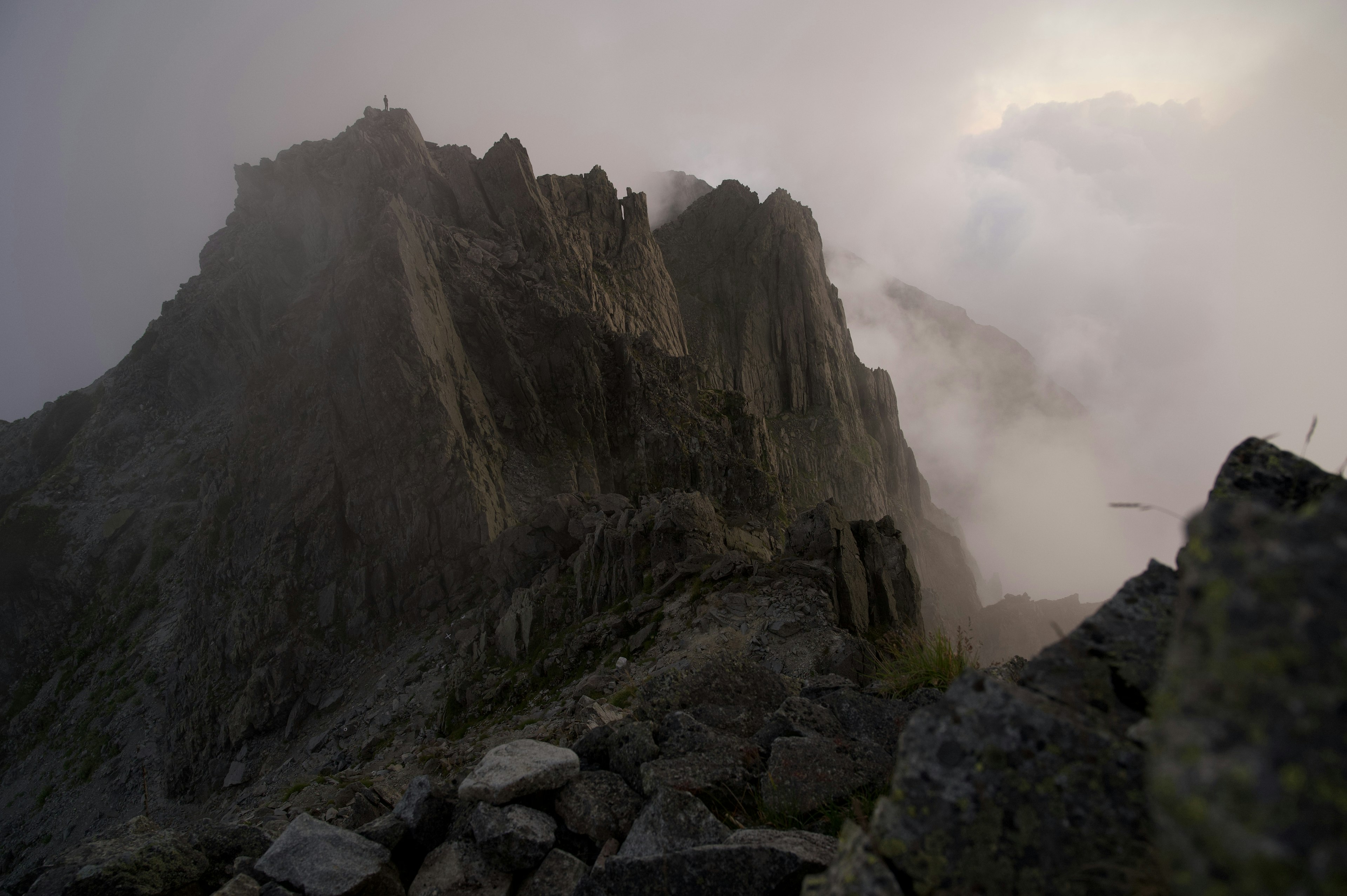 Sommet de montagne couvert de brouillard avec un terrain rocheux