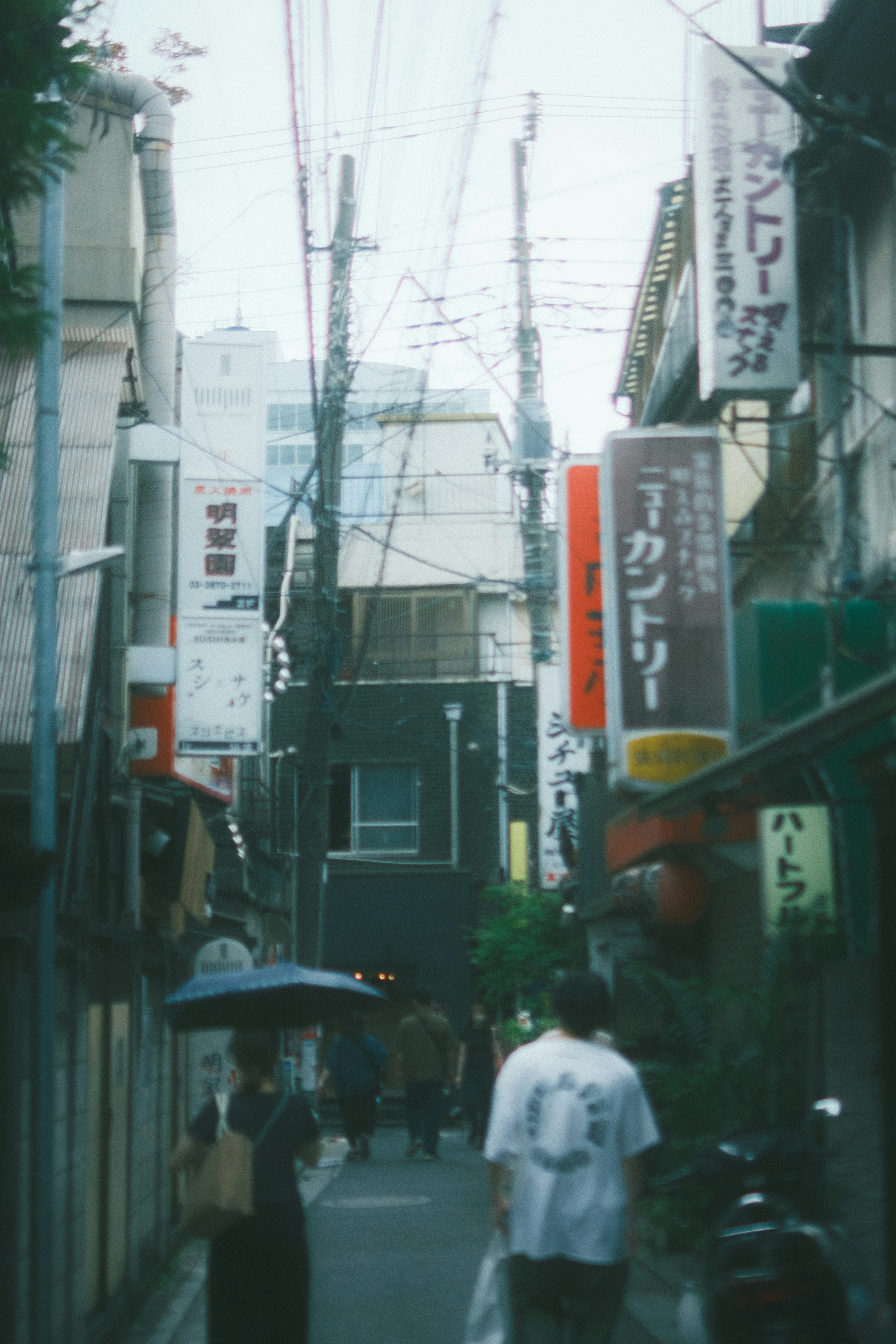 Narrow alley lined with restaurant signs and pedestrians