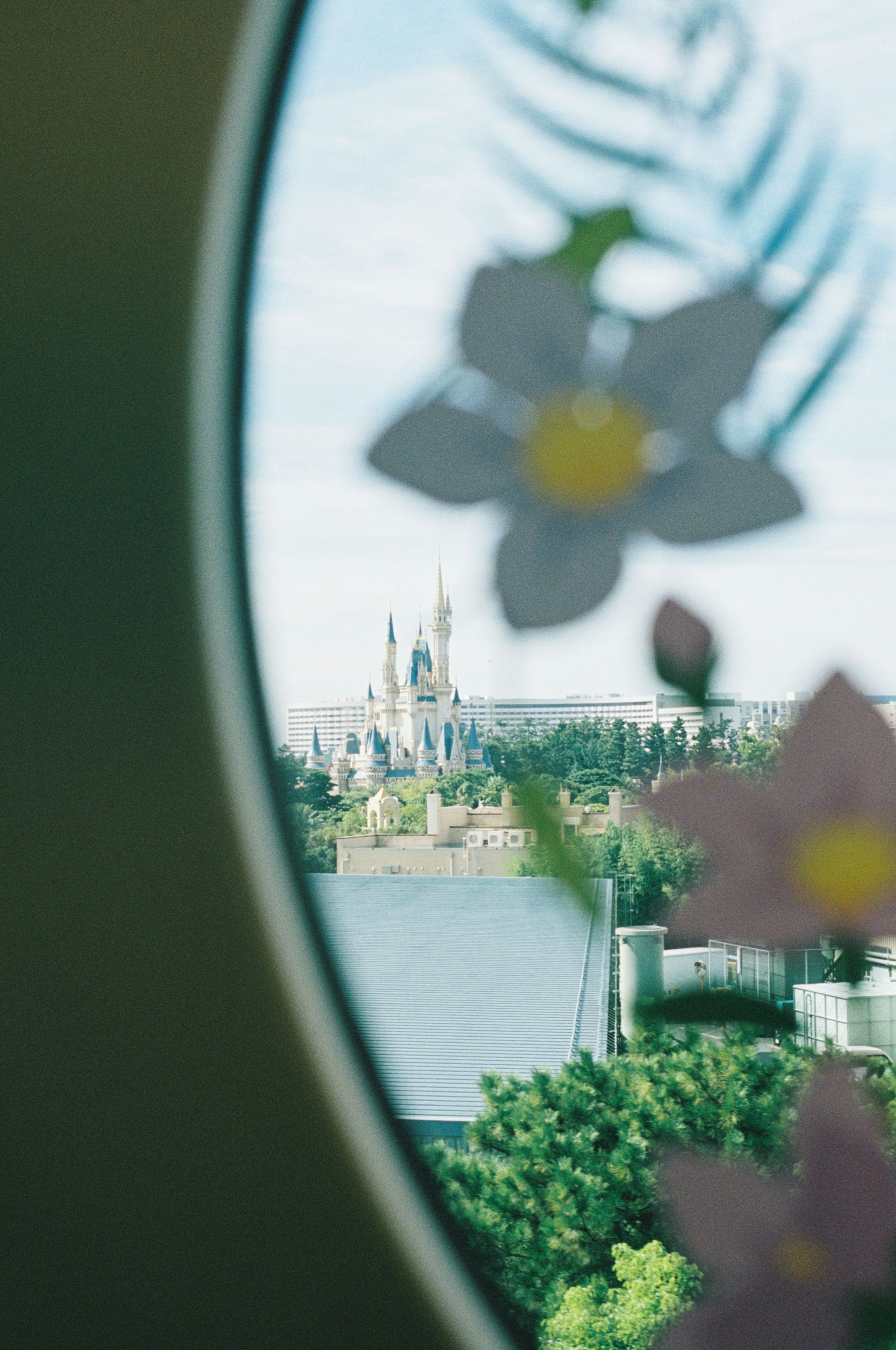 Blick auf ein Schloss durch ein Fenster mit Blumenmotiven