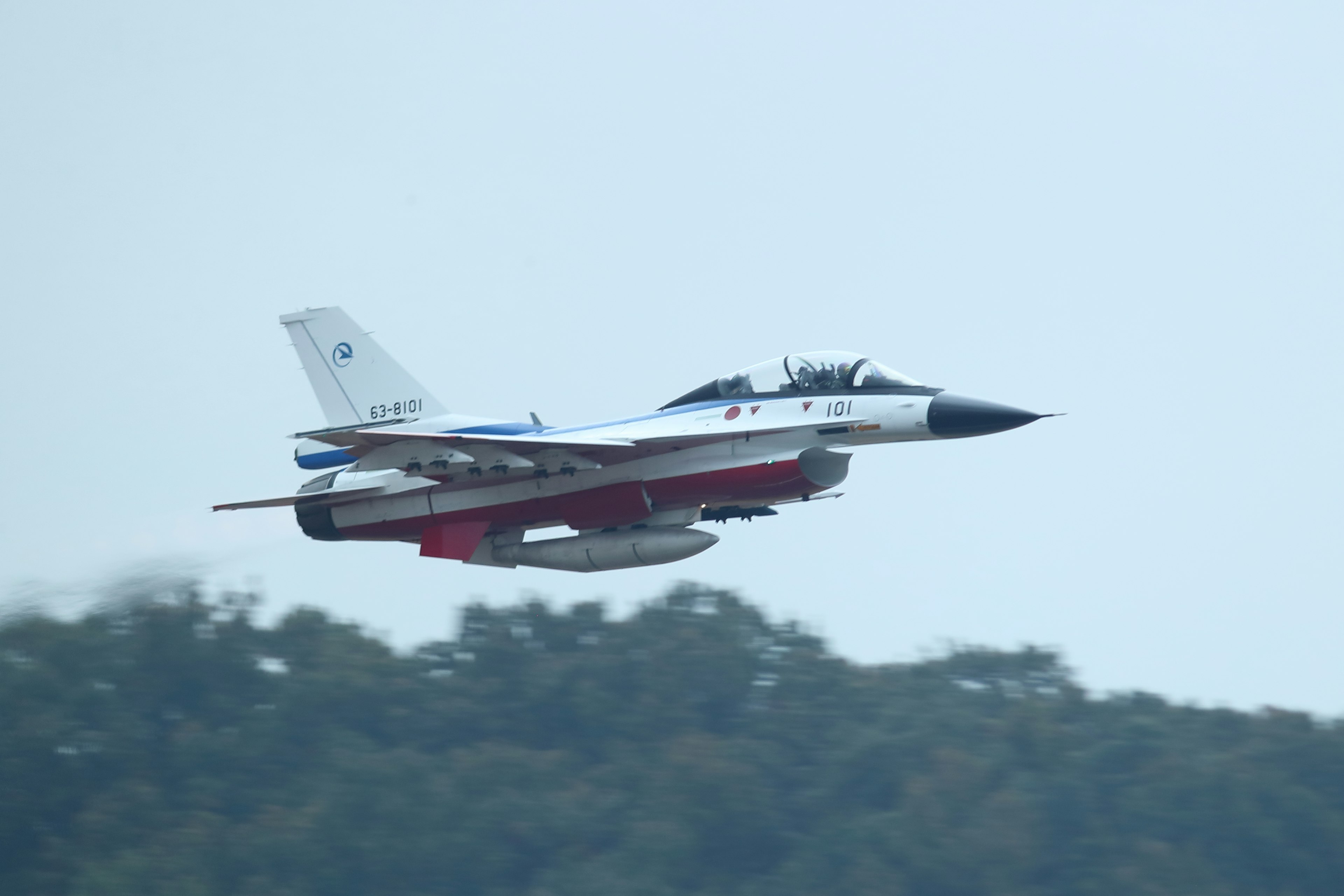 Un caza blanco y rojo volando en el aire