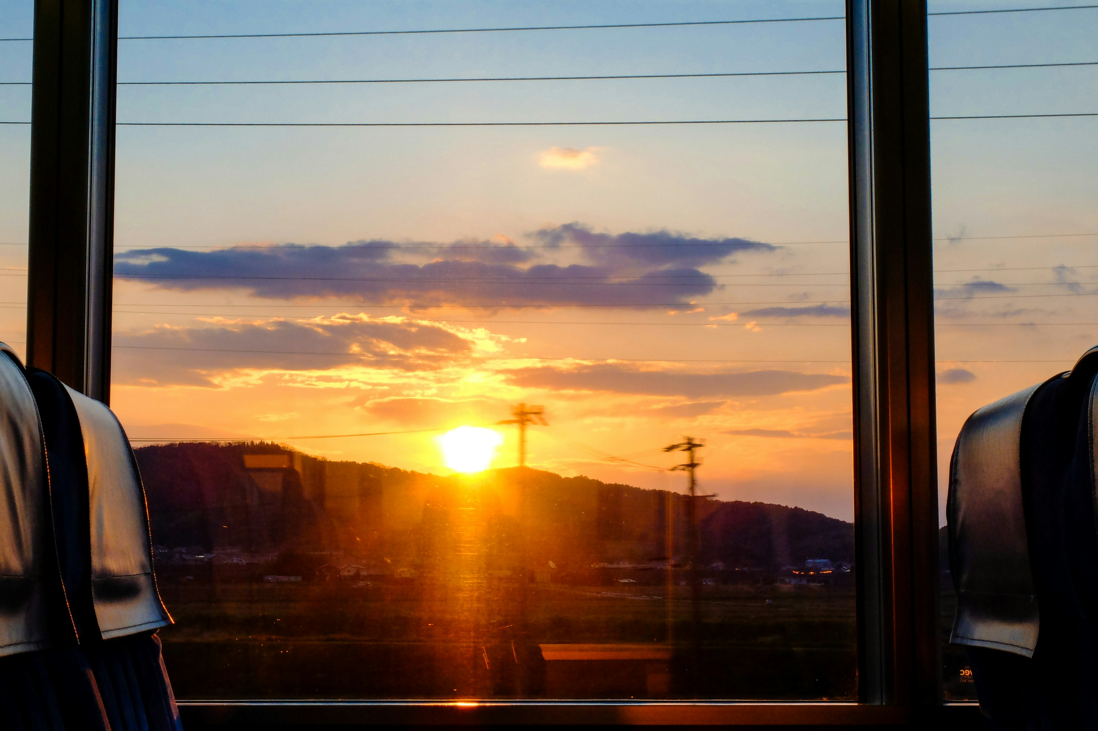 Sunset view from a bus window with silhouettes of seats