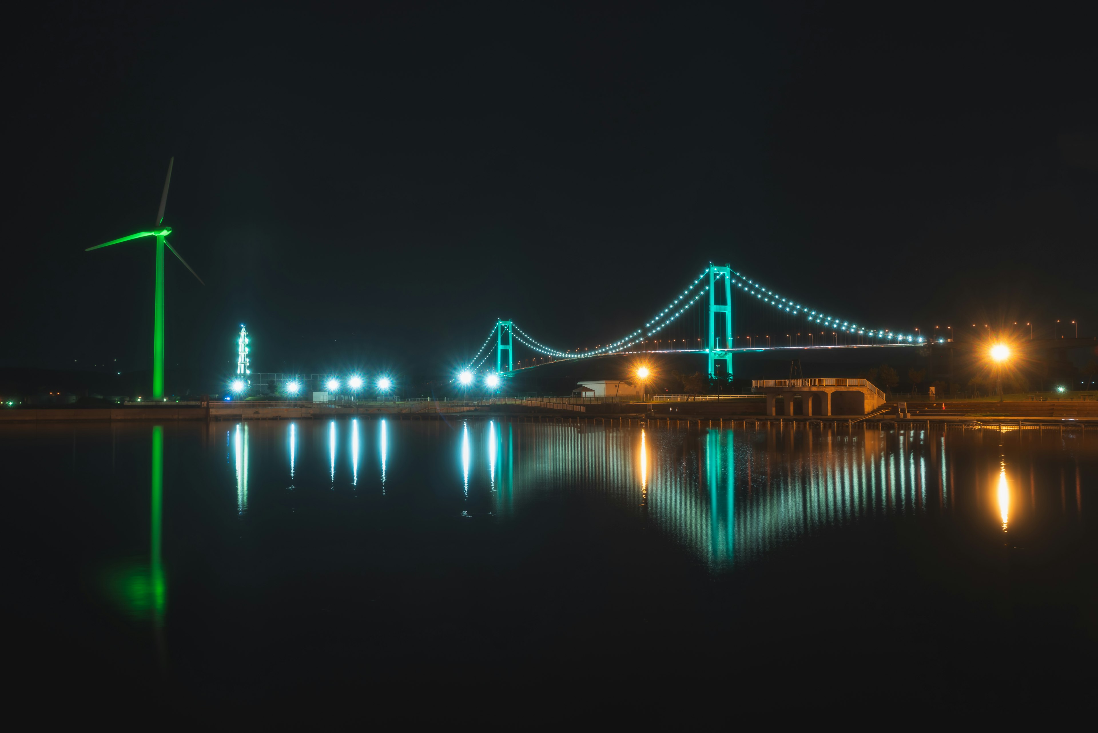 Vista panoramica di un ponte e di una turbina eolica di notte