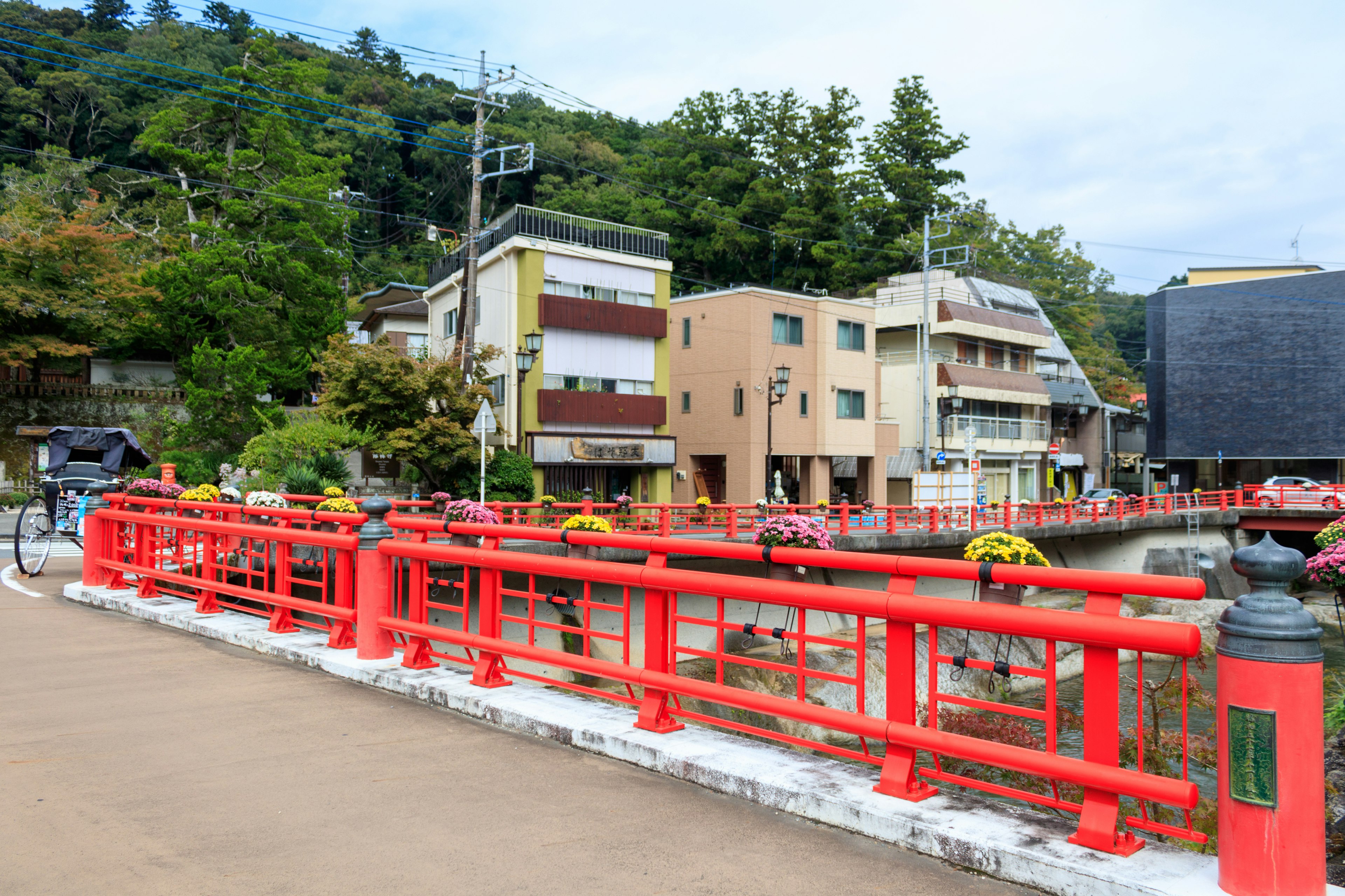 A scenic view featuring a red bridge and surrounding buildings