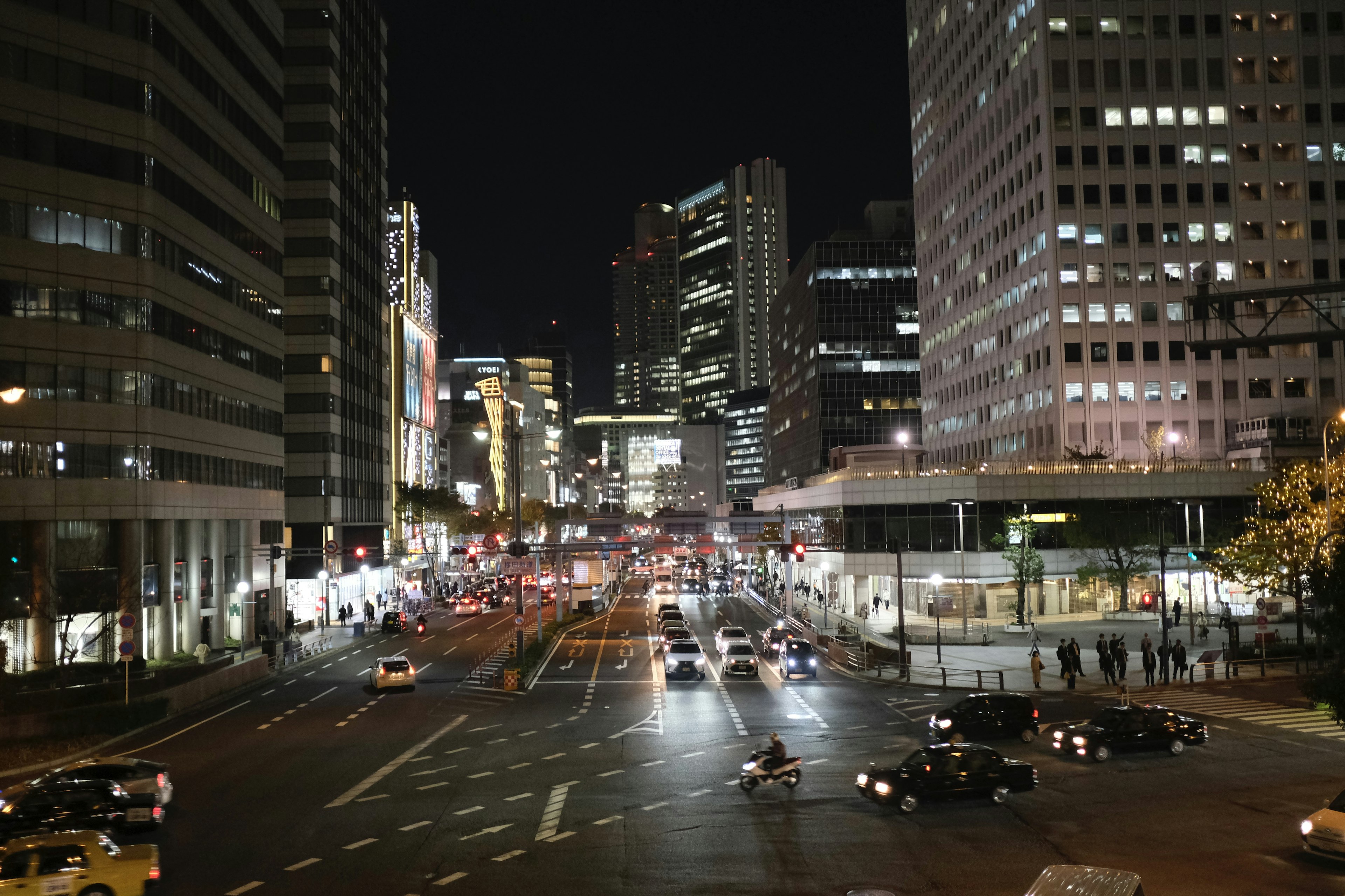 Night cityscape featuring illuminated skyscrapers and bustling traffic