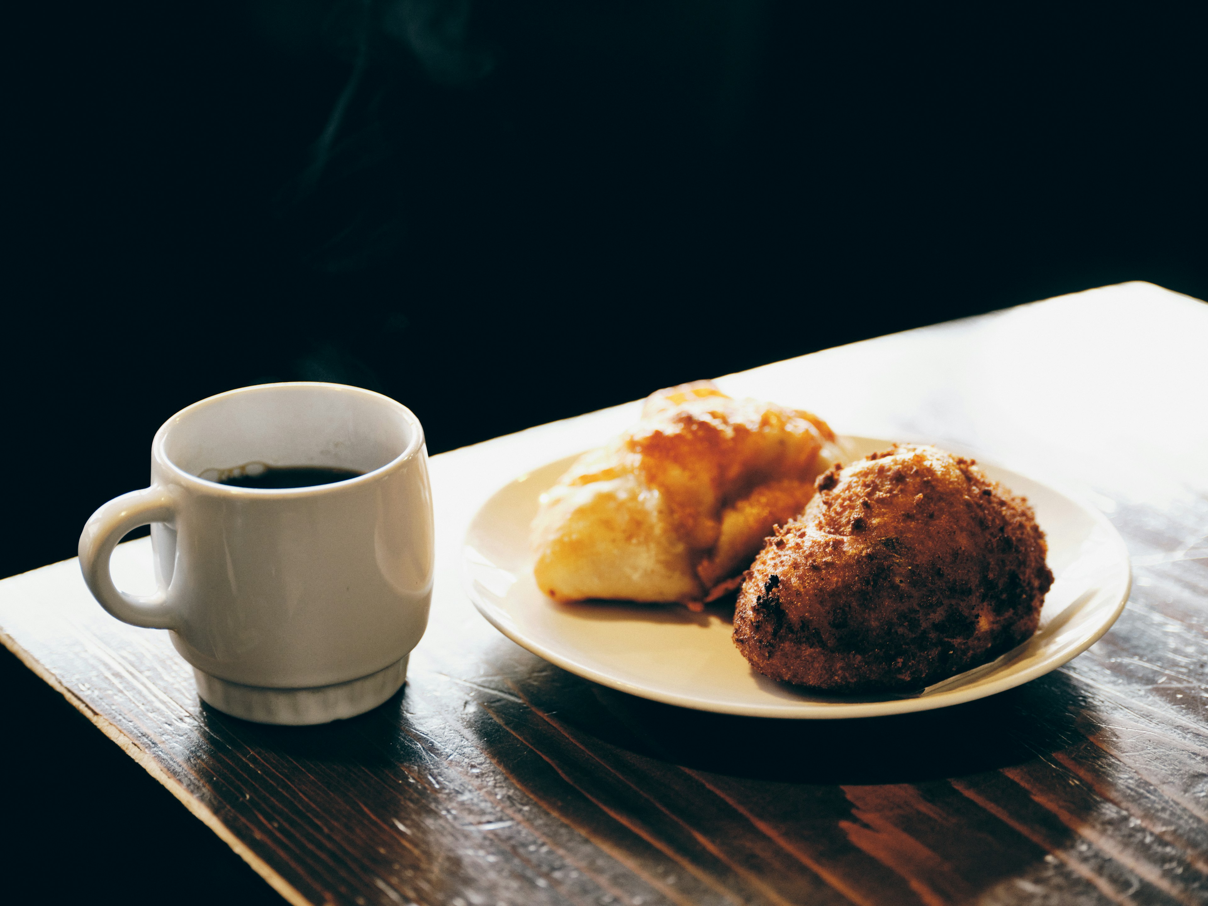 Sebuah pemandangan nyaman dengan kopi dan kue di atas meja kayu