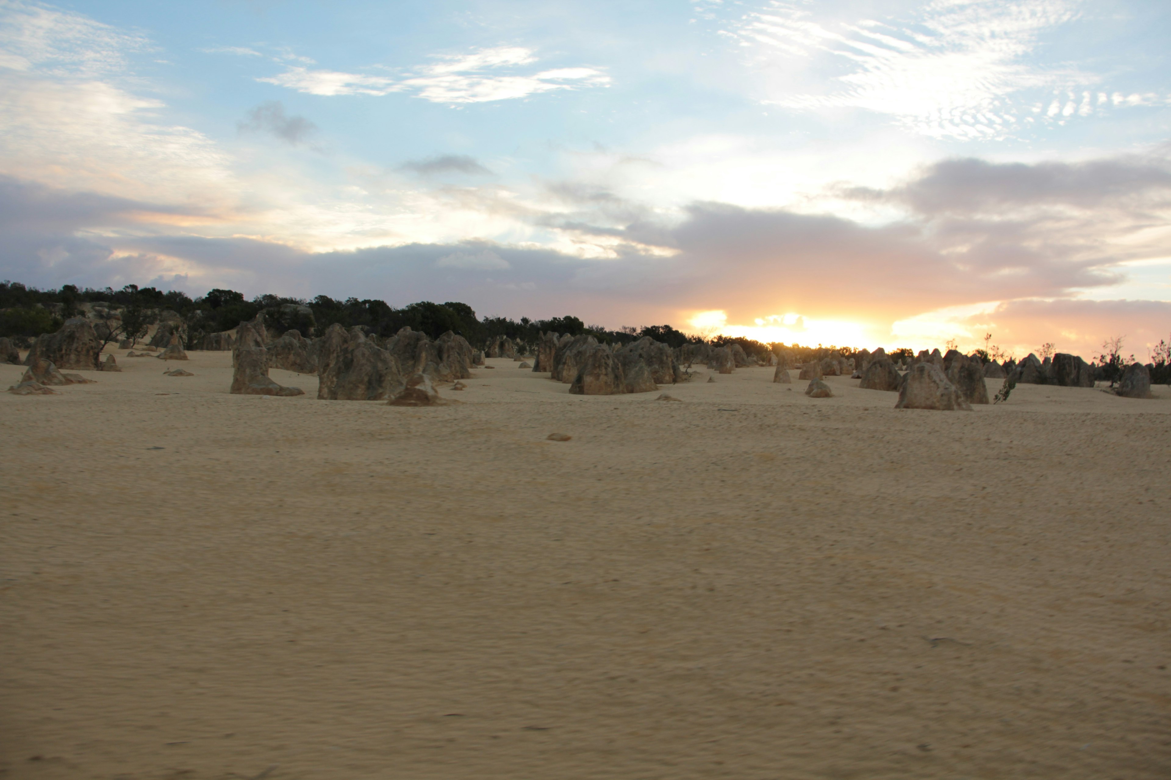 Landscape with sunset sky and shadows of sand dunes