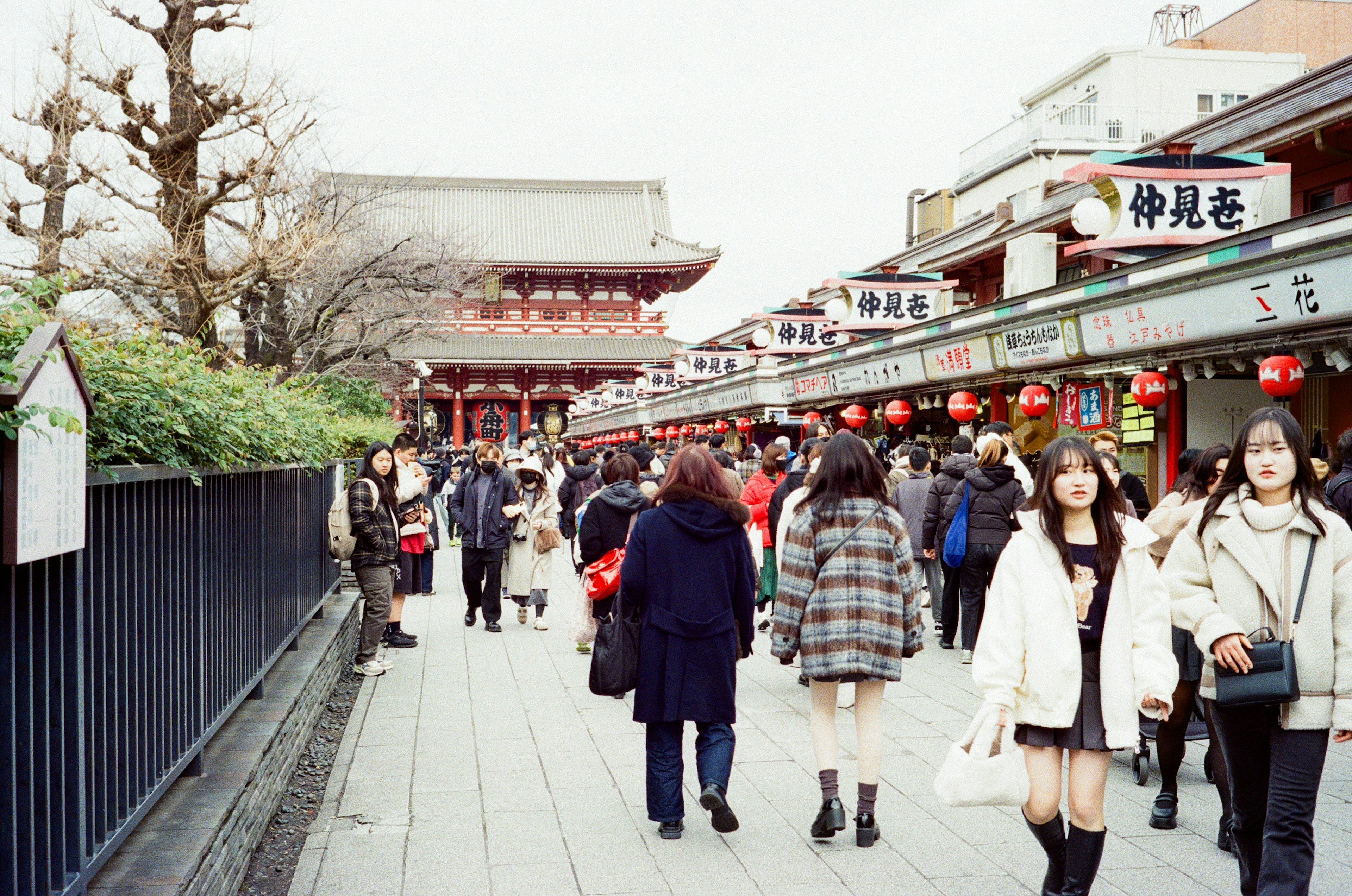 Bustling street scene with people walking in a shopping area