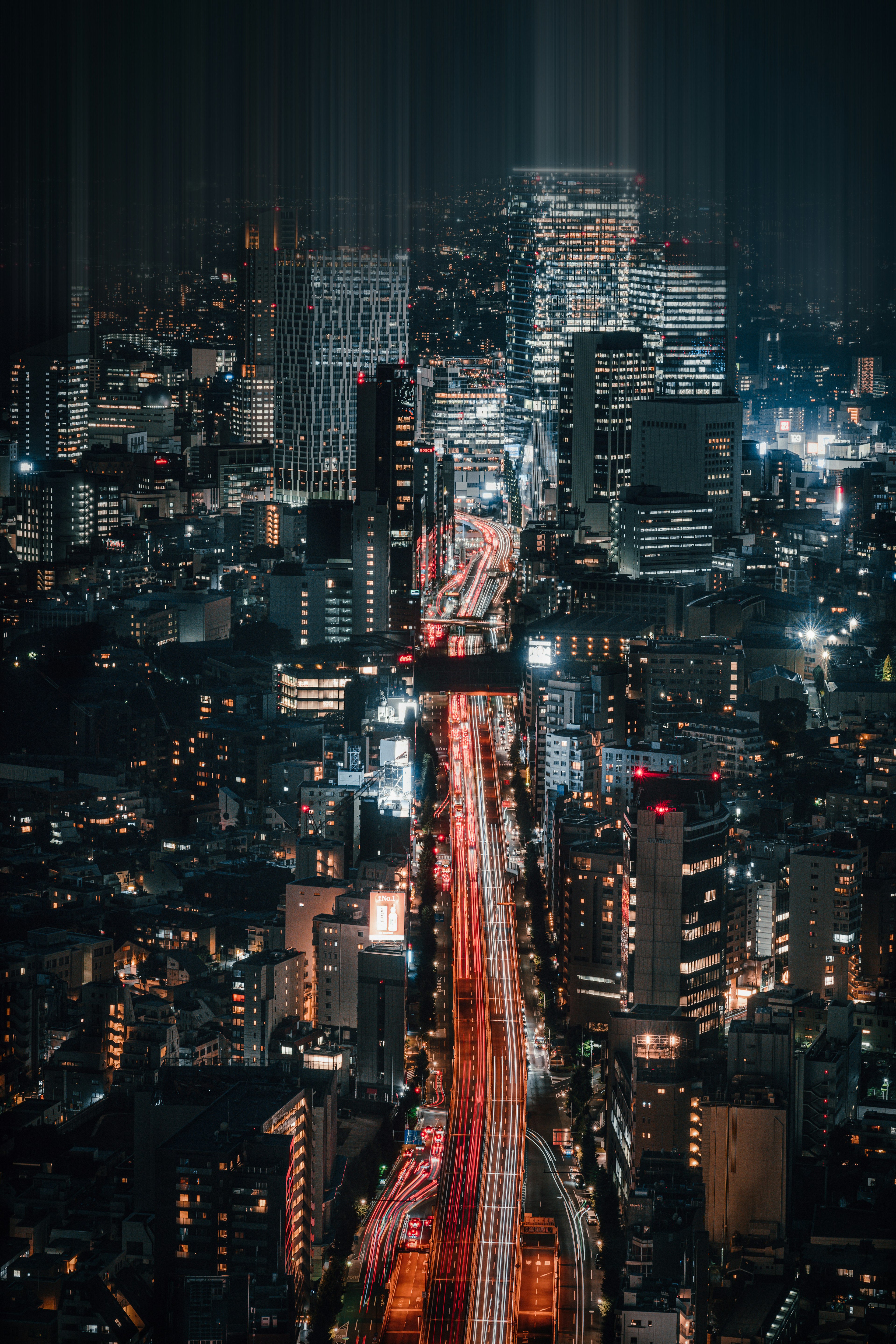 Paisaje urbano nocturno con rascacielos y carreteras iluminadas