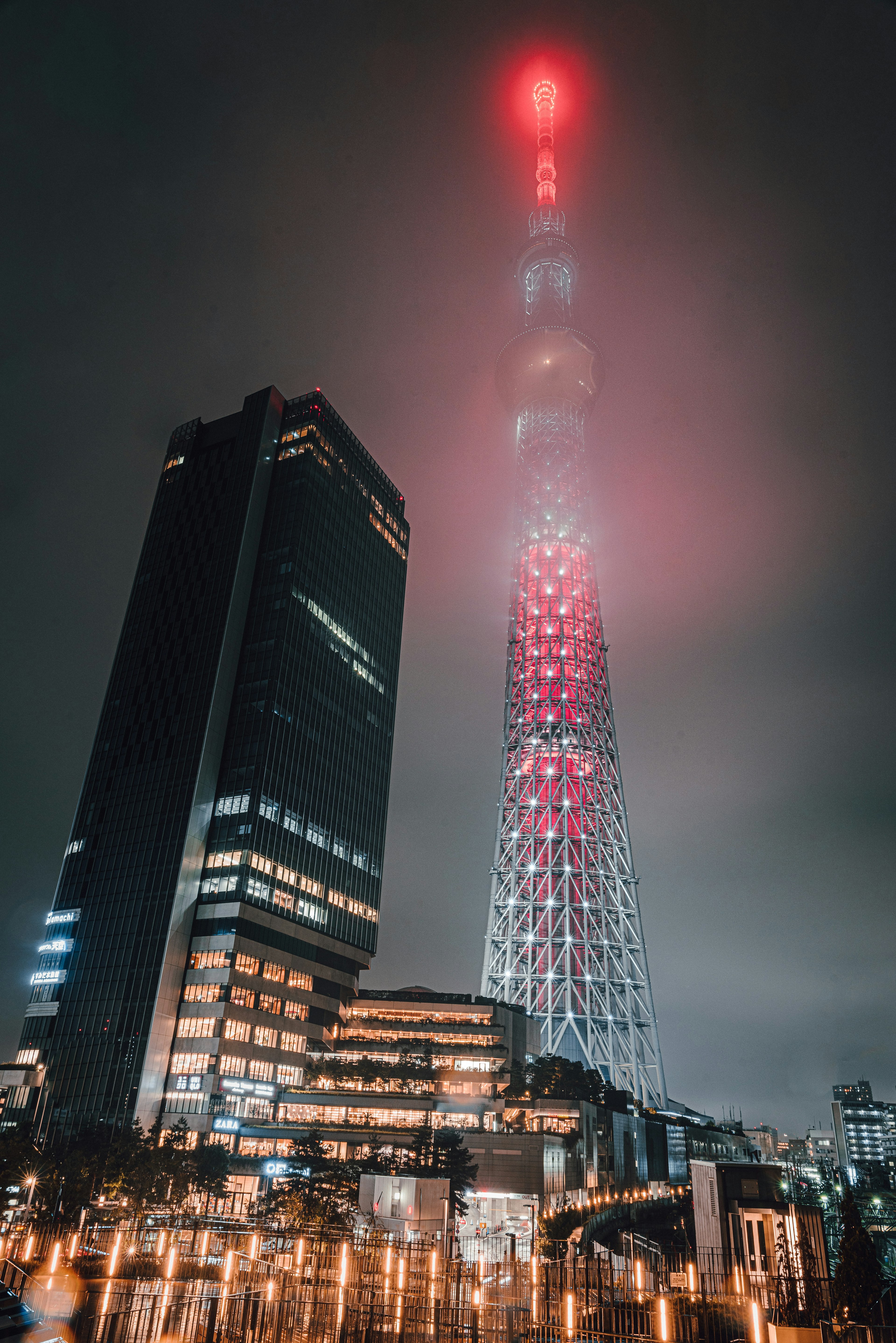 Tokyo Skytree illuminato di notte circondato dalla nebbia