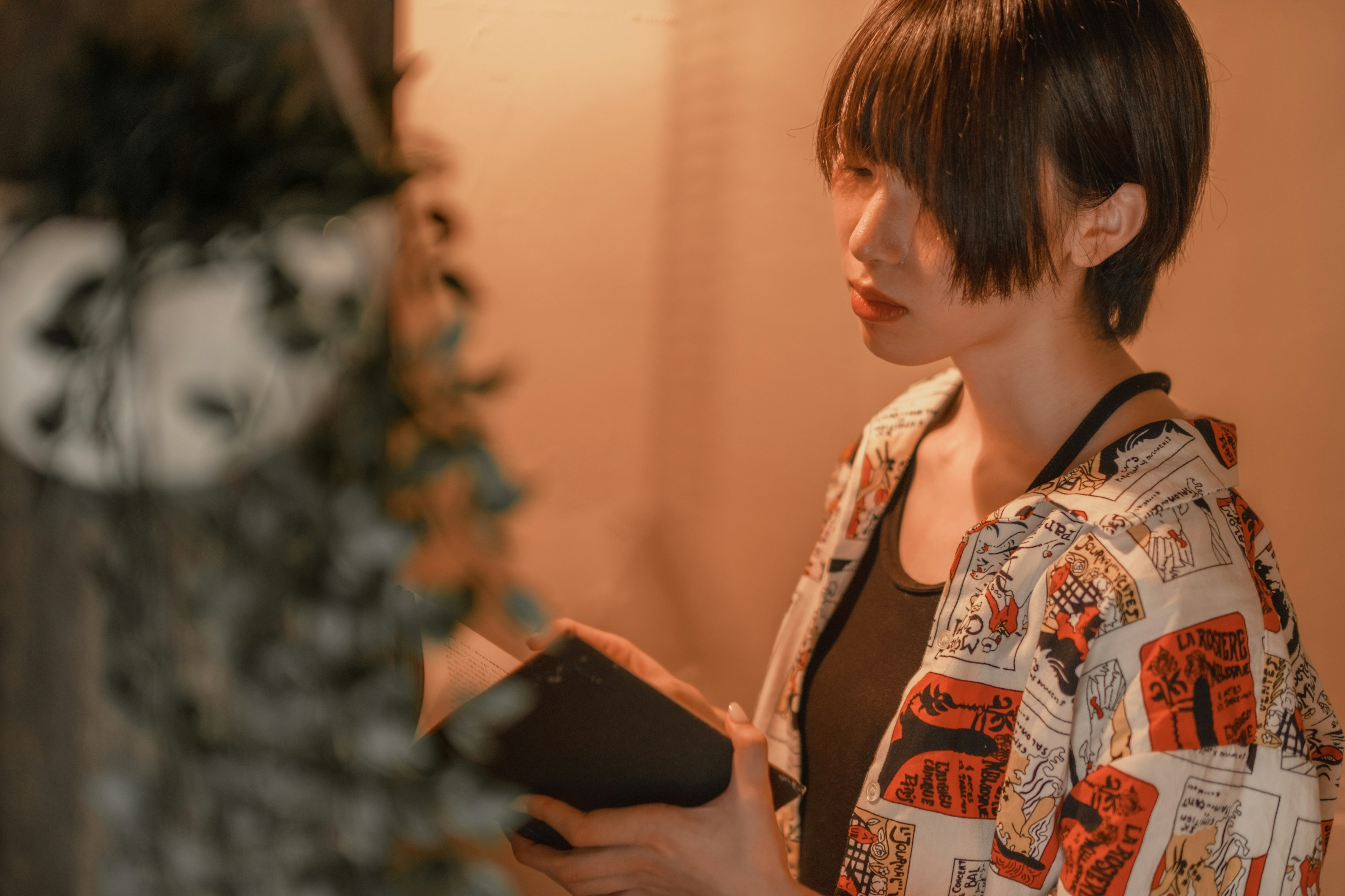 A woman holding a book with a contemplative expression Soft lighting creates a calm atmosphere