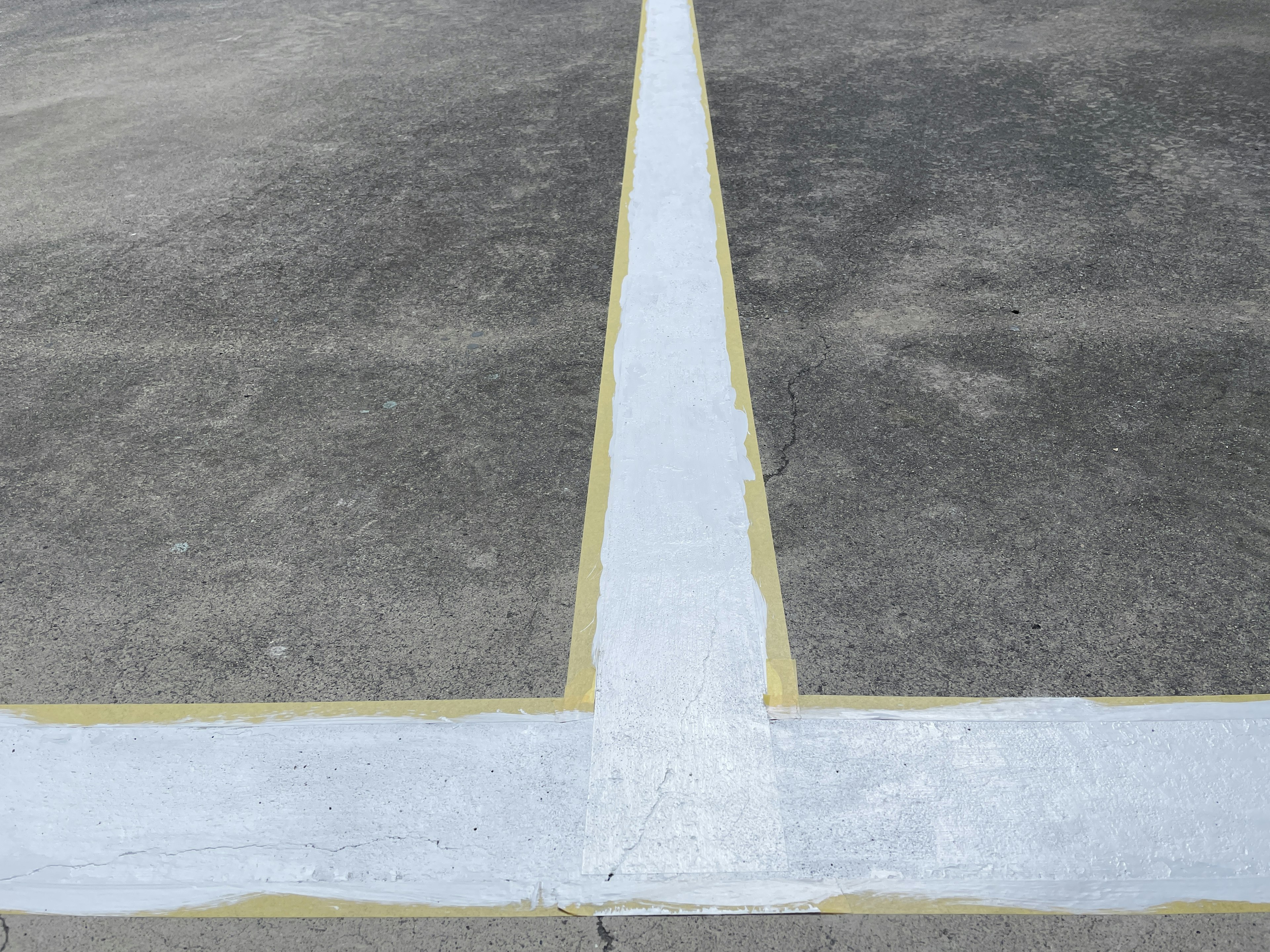 White line and yellow border painted on concrete surface