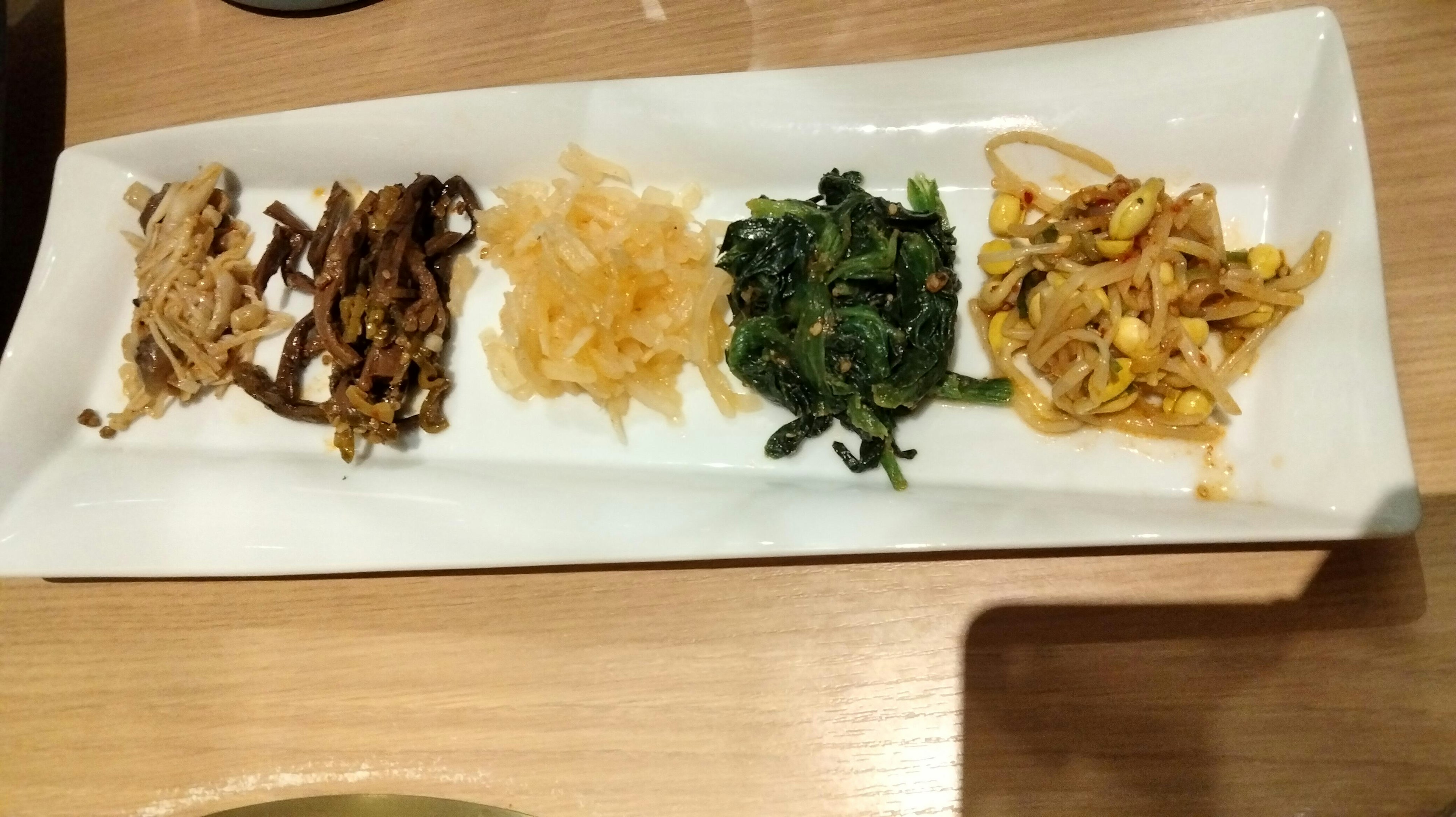 Five varieties of Korean namul arranged on a white plate