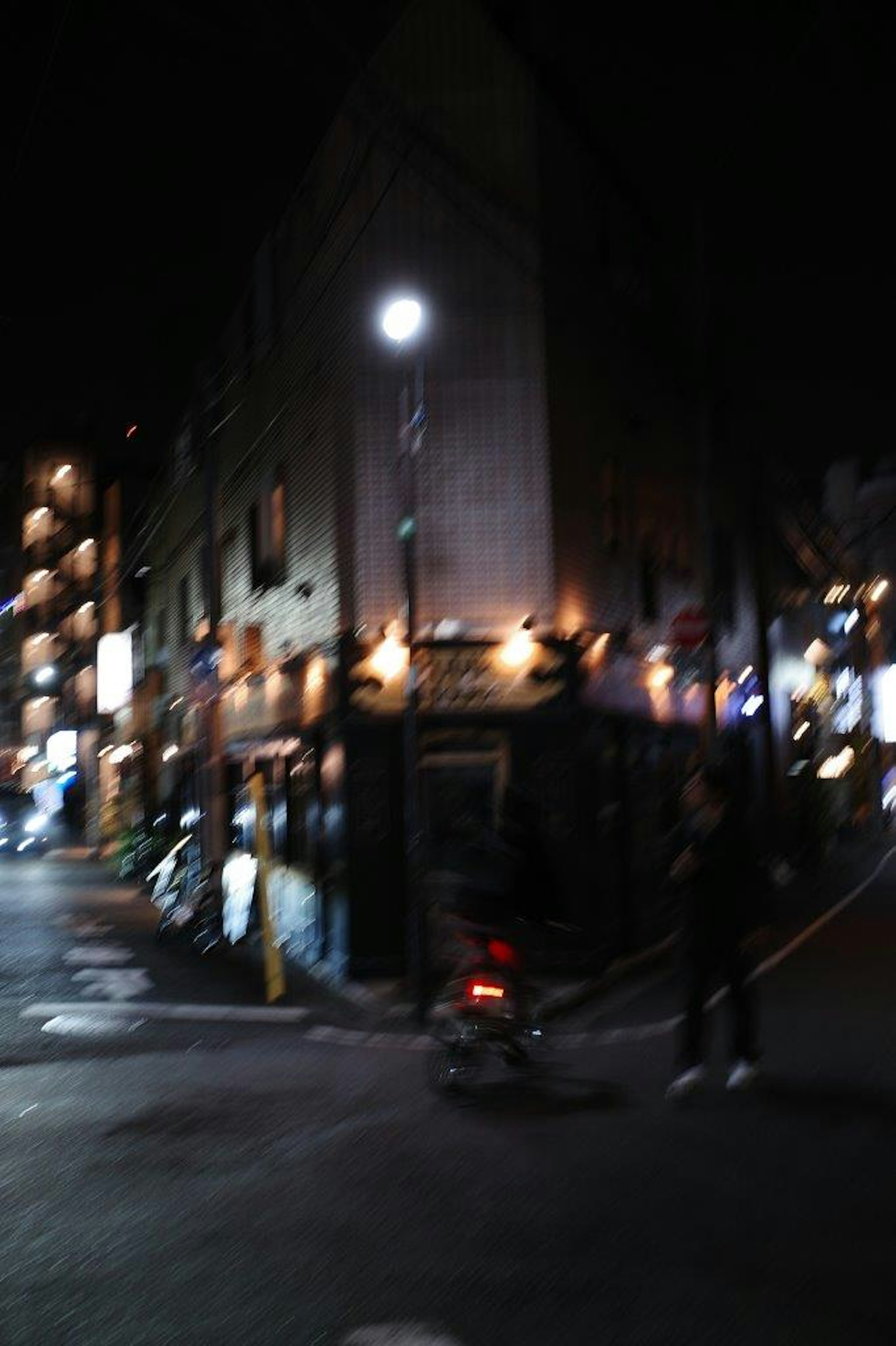 夜の街角の風景 照明が灯る建物と人影