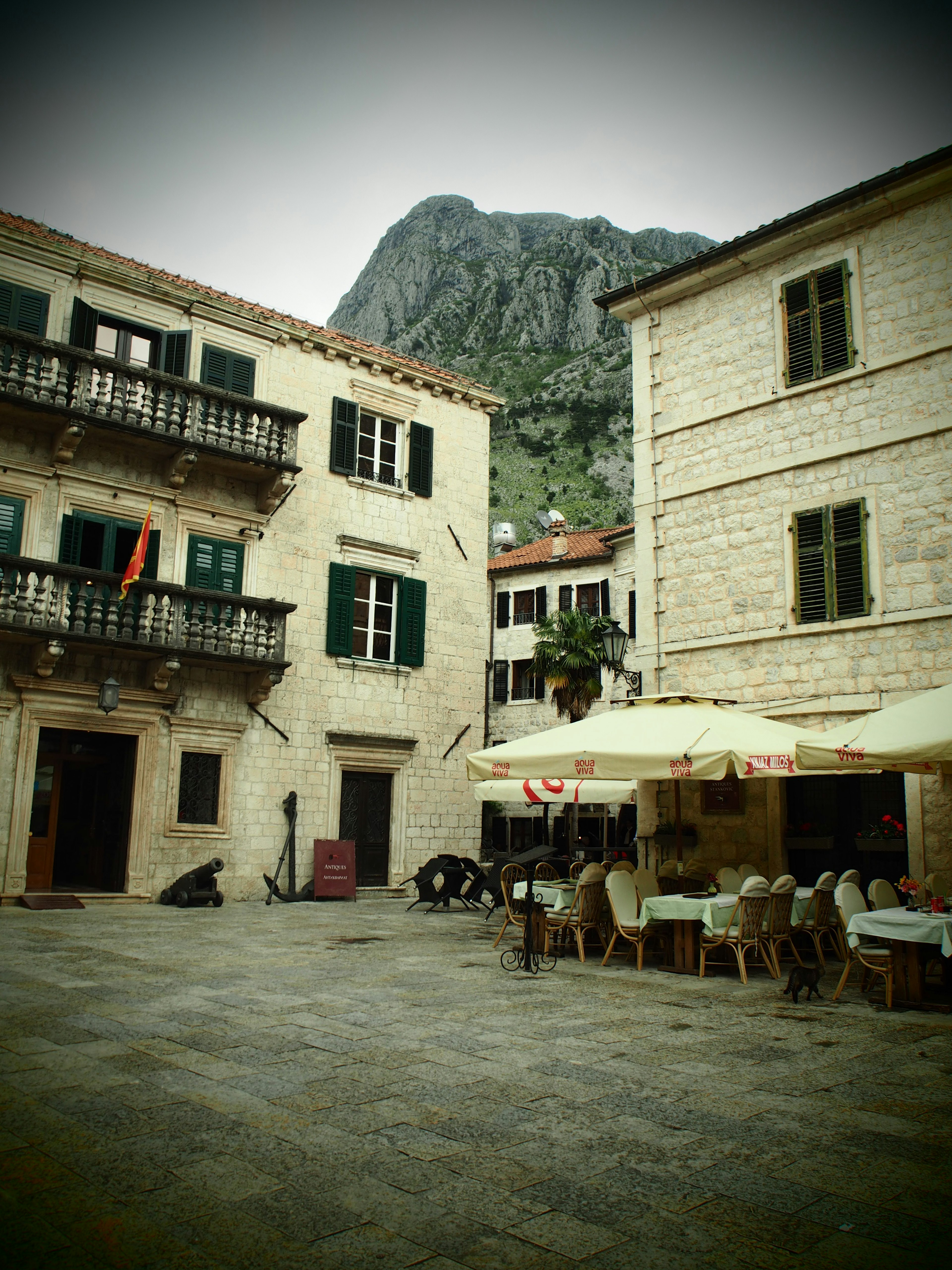 Affascinanti edifici in pietra con una terrazza e una montagna sullo sfondo