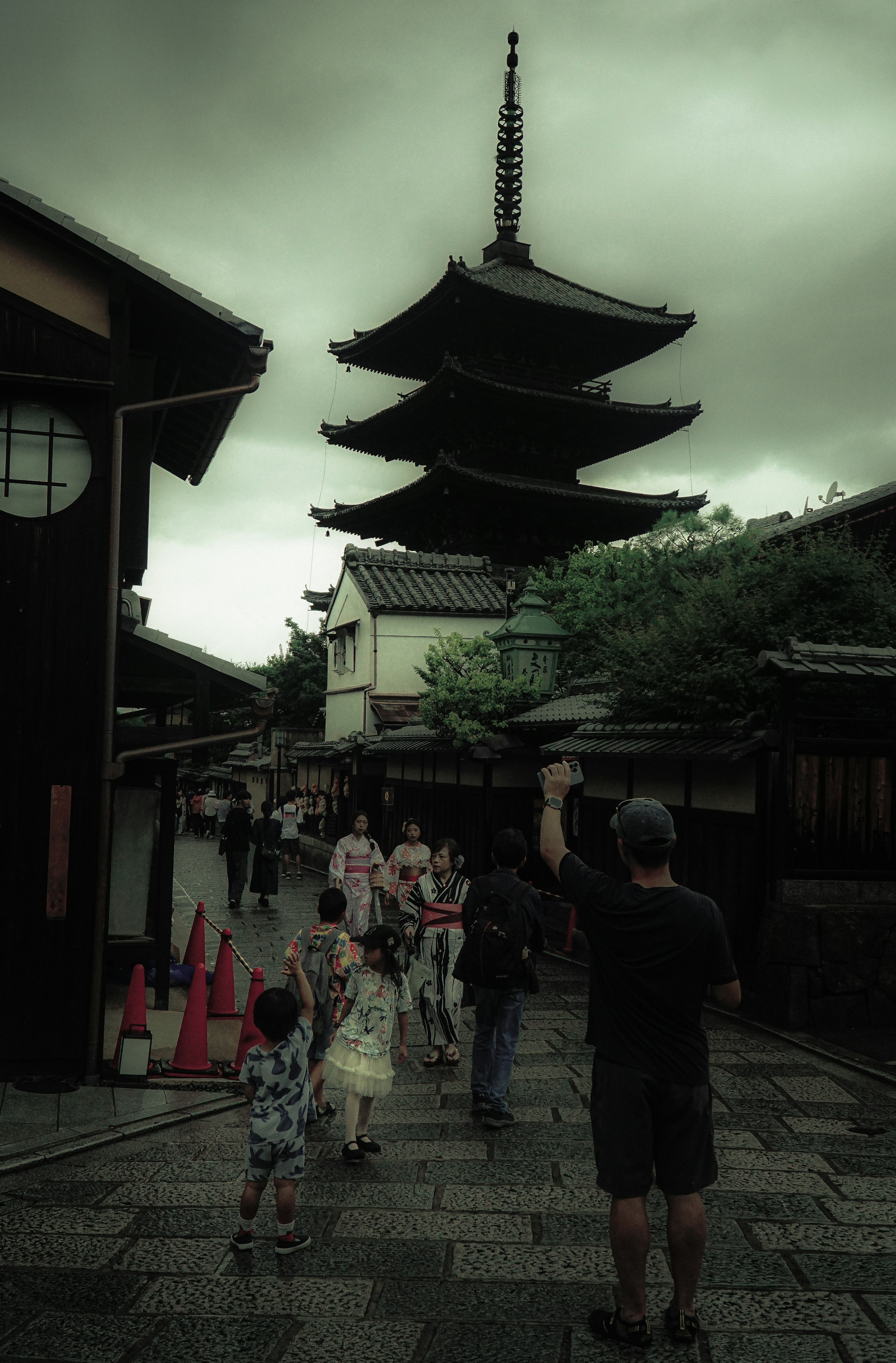 Vista escénica de una calle tradicional con una pagoda al fondo y personas caminando