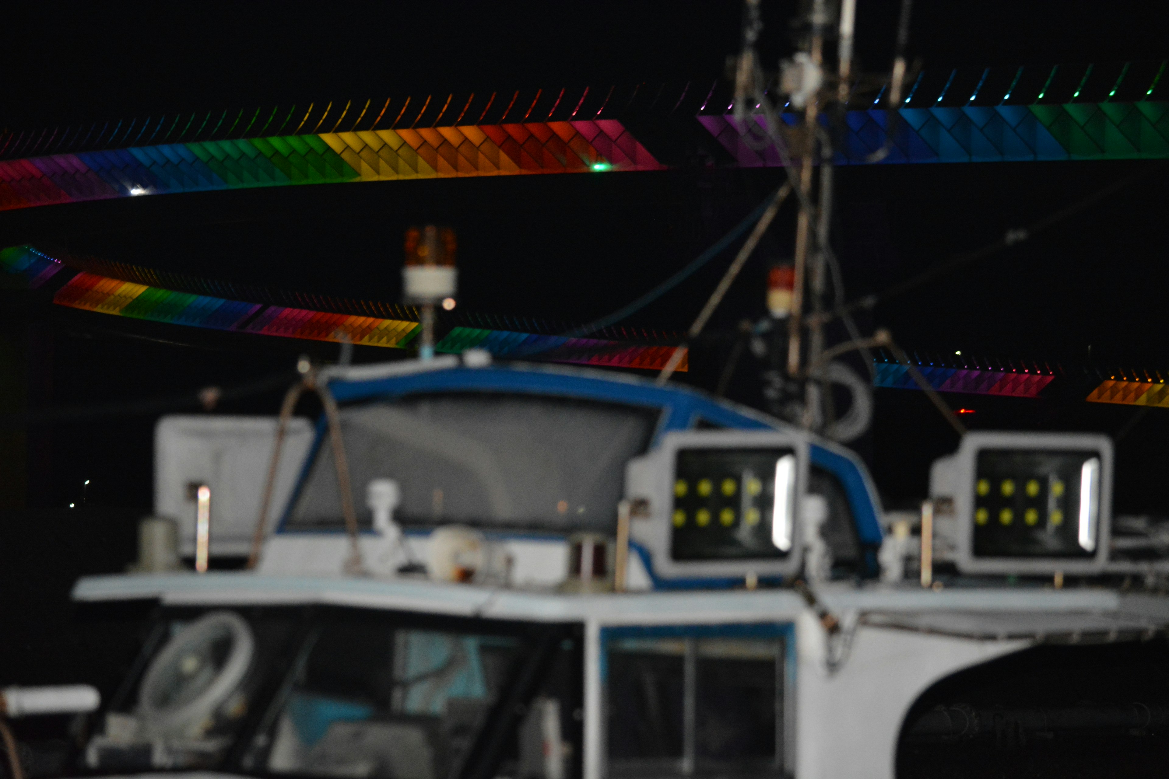 Partie d'un bateau éclairé par des lumières colorées la nuit