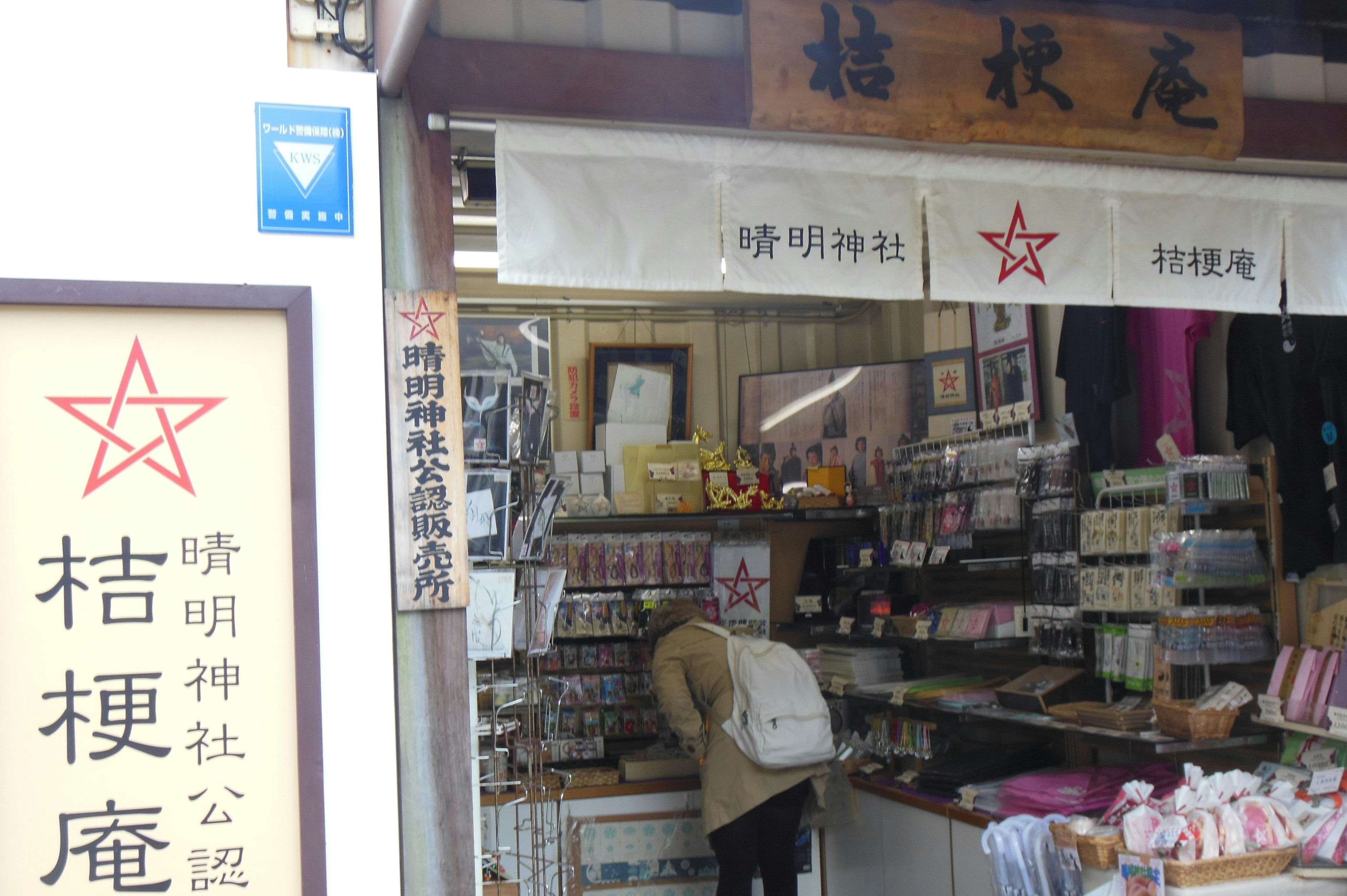 Exterior of a souvenir shop in front of a shrine displaying various products