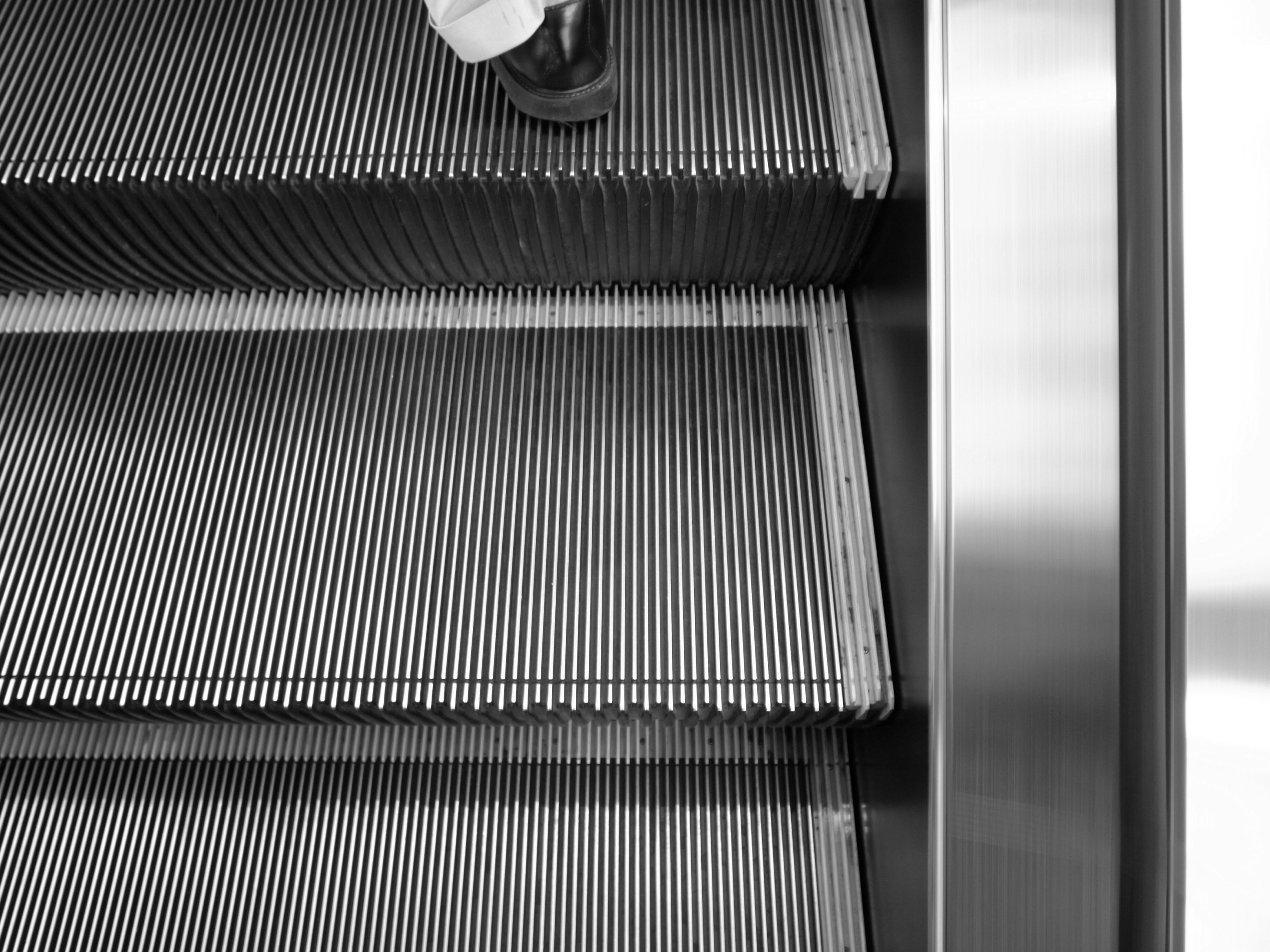 Close-up of escalator steps with a person's foot