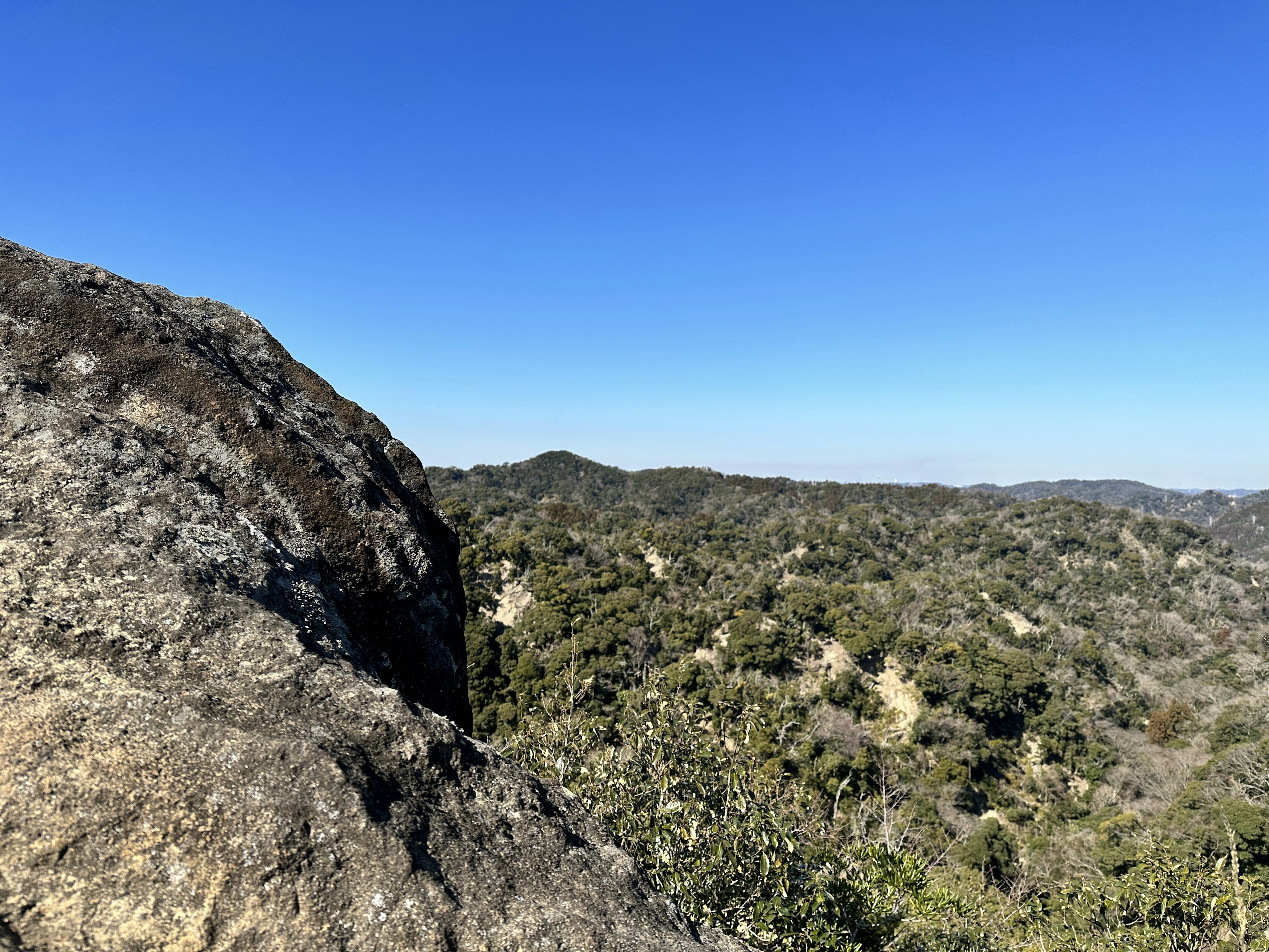 Paysage rocheux avec un ciel bleu clair et des collines lointaines