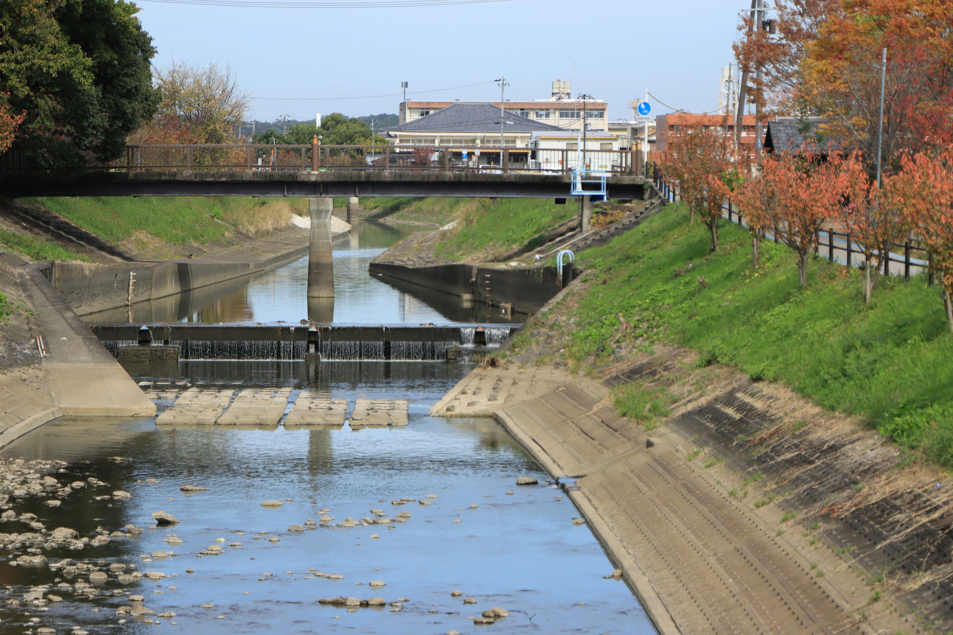 Paisaje fluvial con un puente y árboles de otoño coloridos