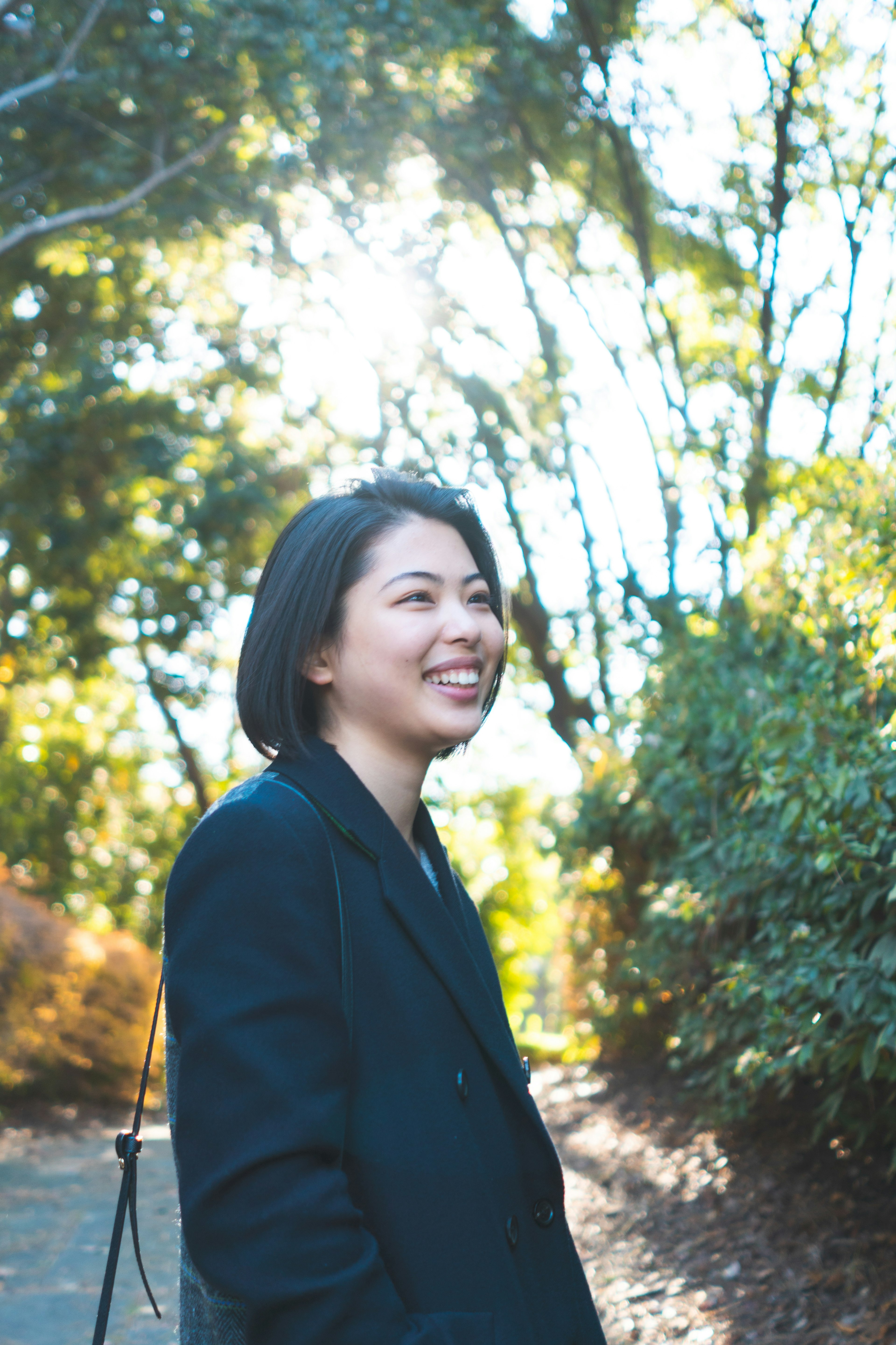 Portrait of a smiling woman in a lush green background