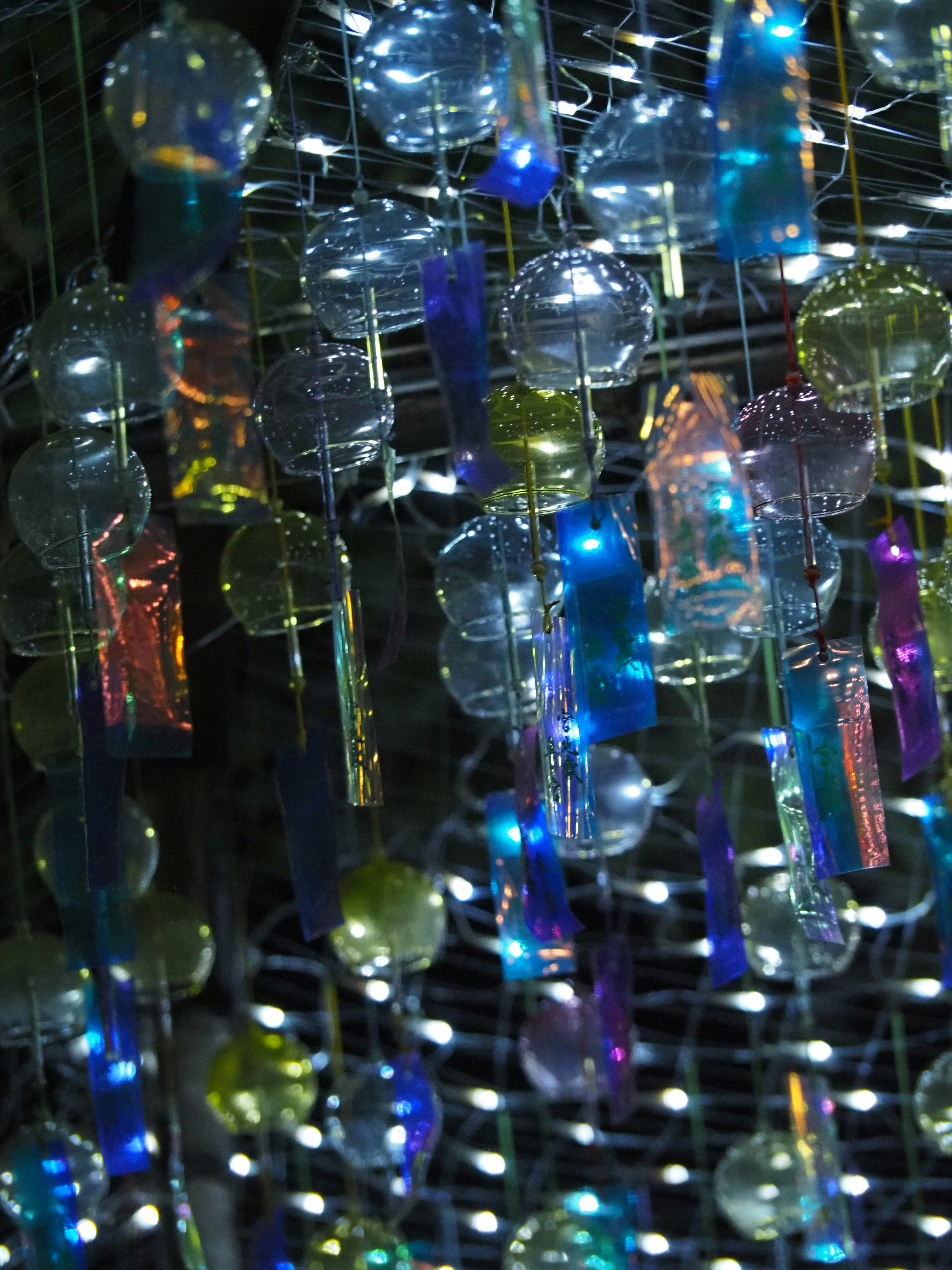 Objets en verre colorés suspendus dans une installation artistique