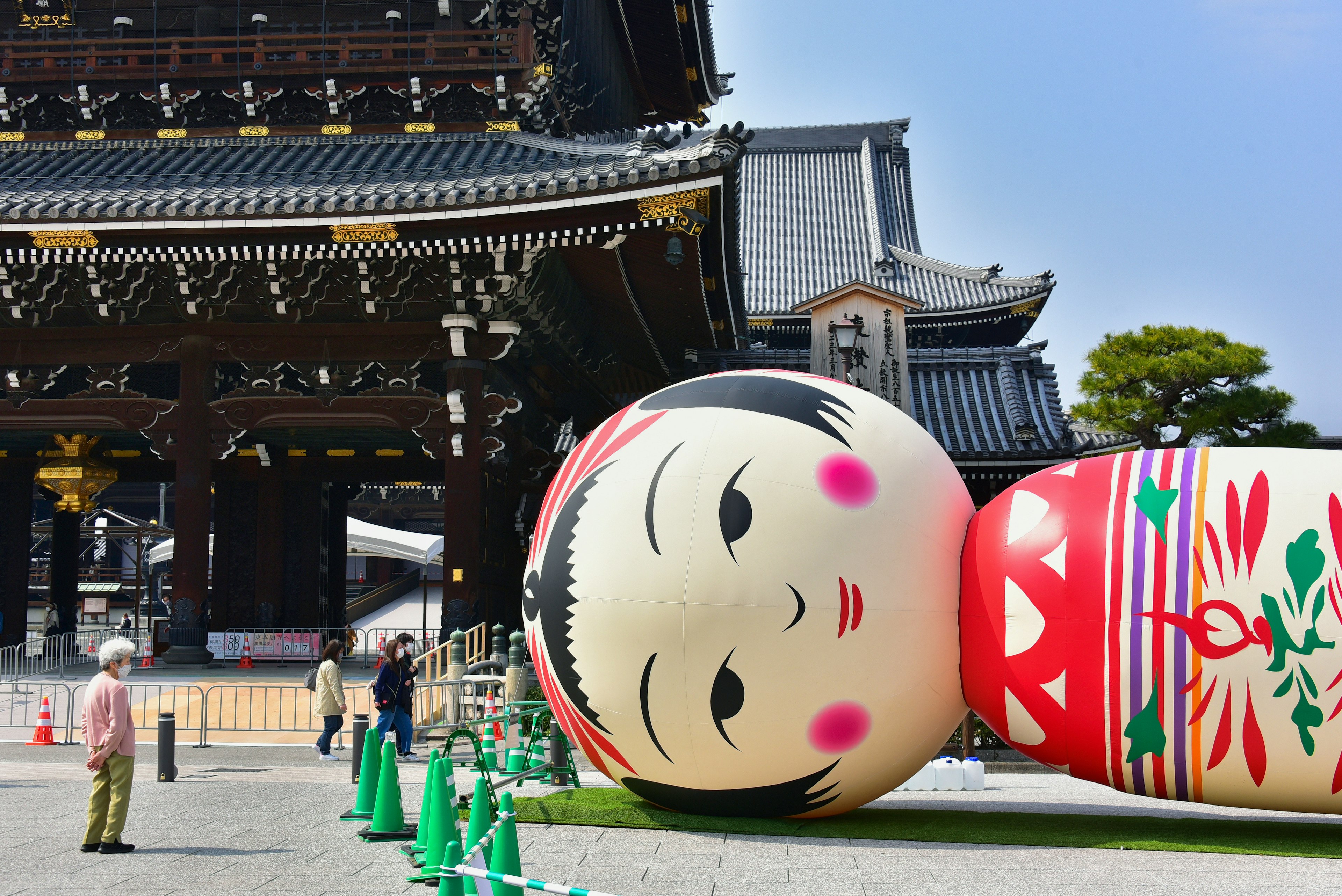 Large Kokeshi doll lying in front of a temple