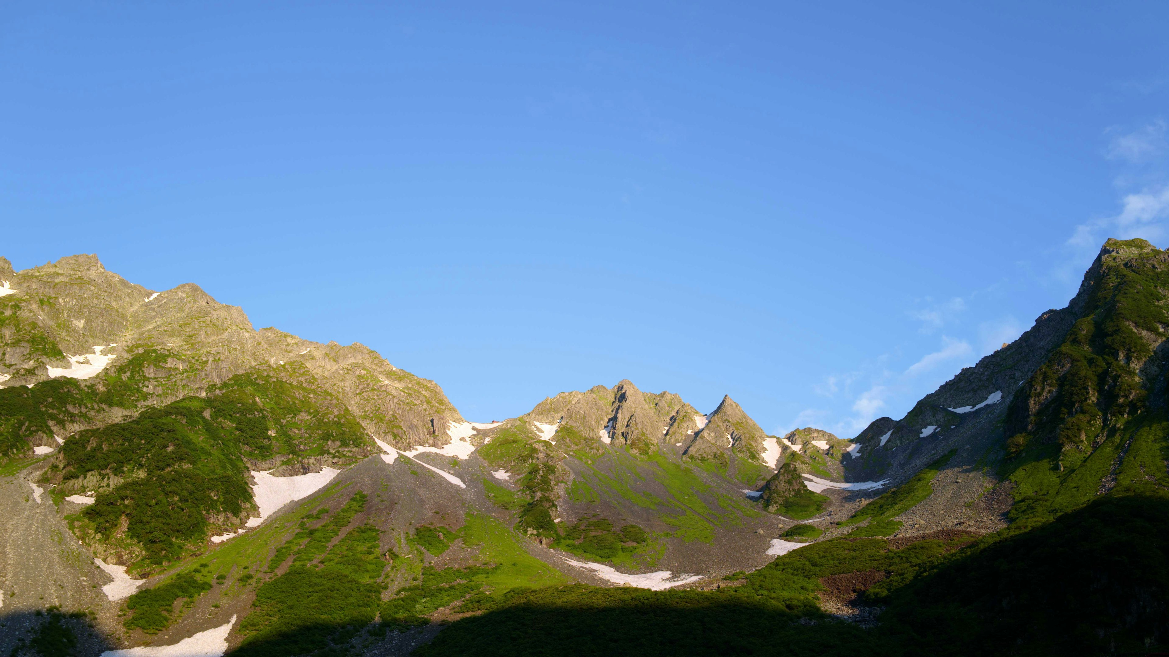 Lush green mountains under a clear blue sky