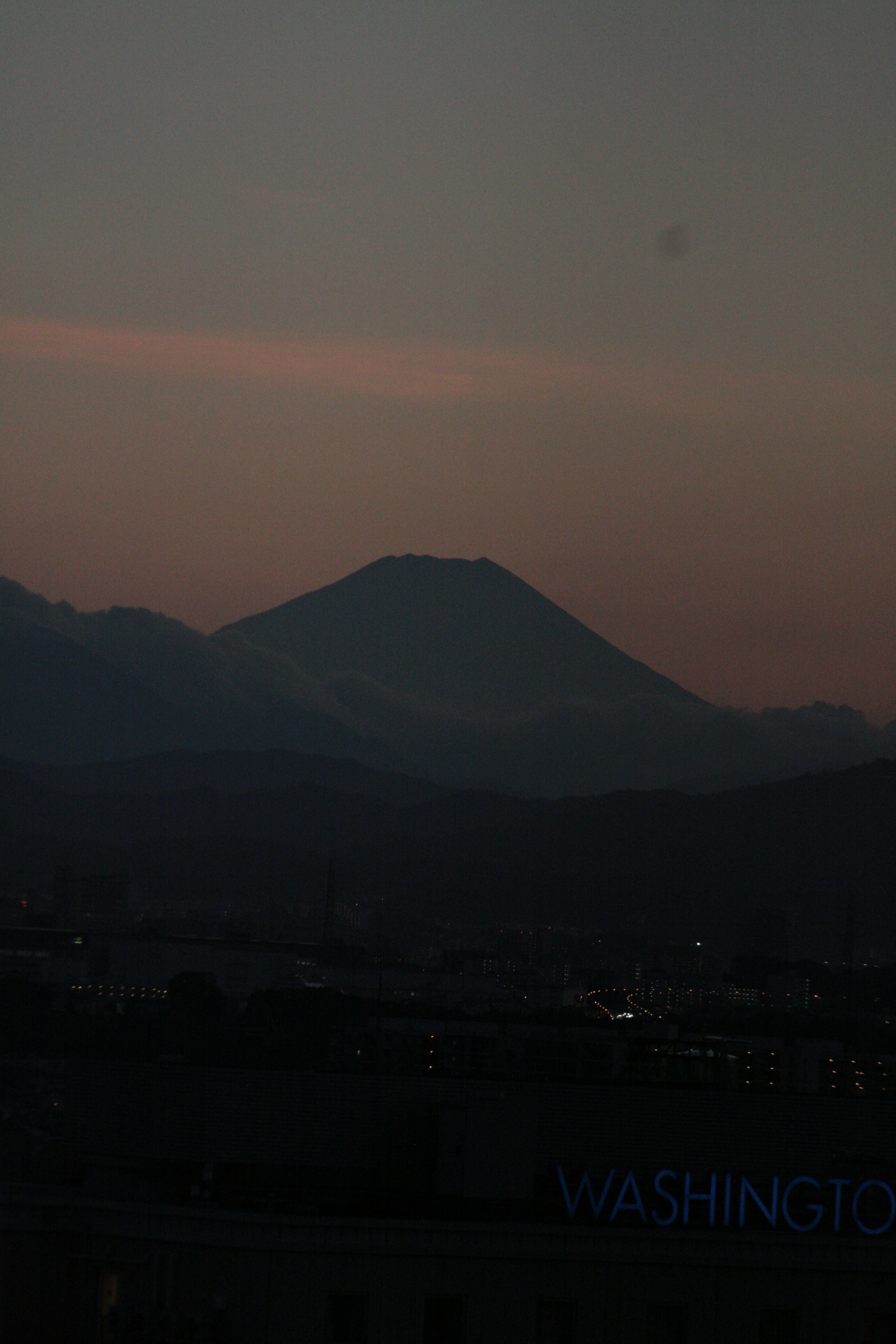 夜の山のシルエットと薄明かりの空